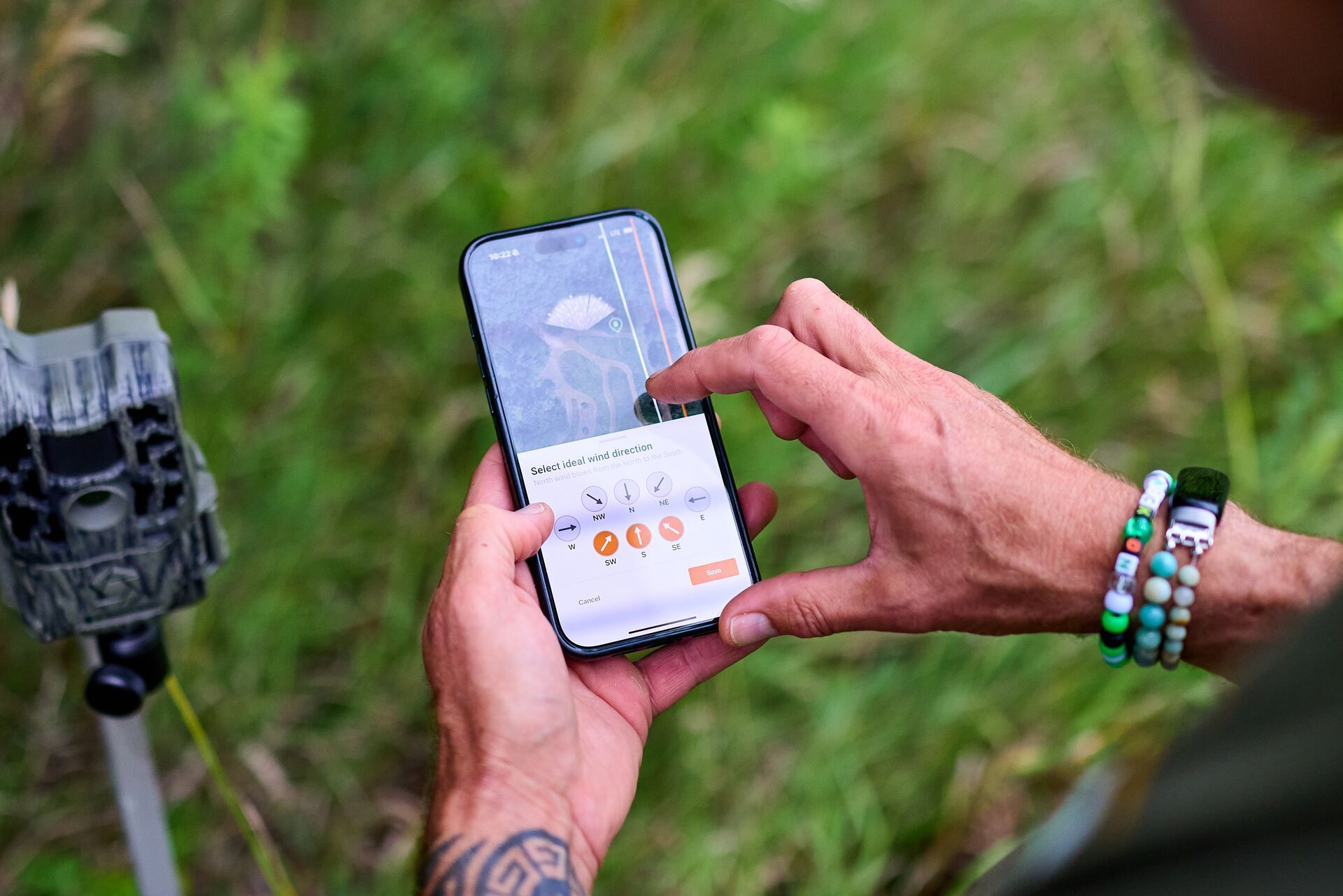 Hunter using HuntWise to set up trail cameras, where can I go hunting near me concept.