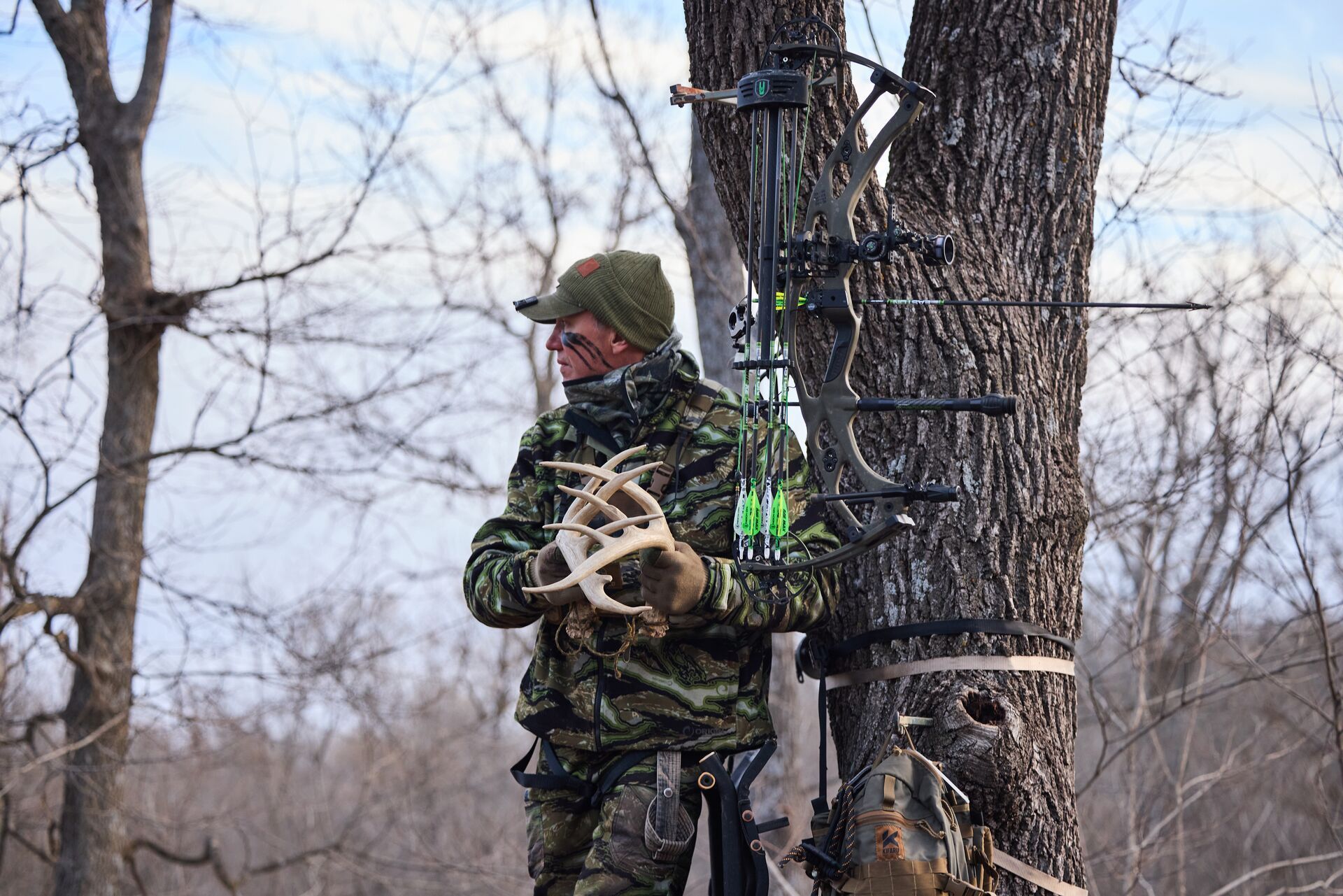 Hunter rattles antlers during hunt, best deer calls for pre-rut concept.