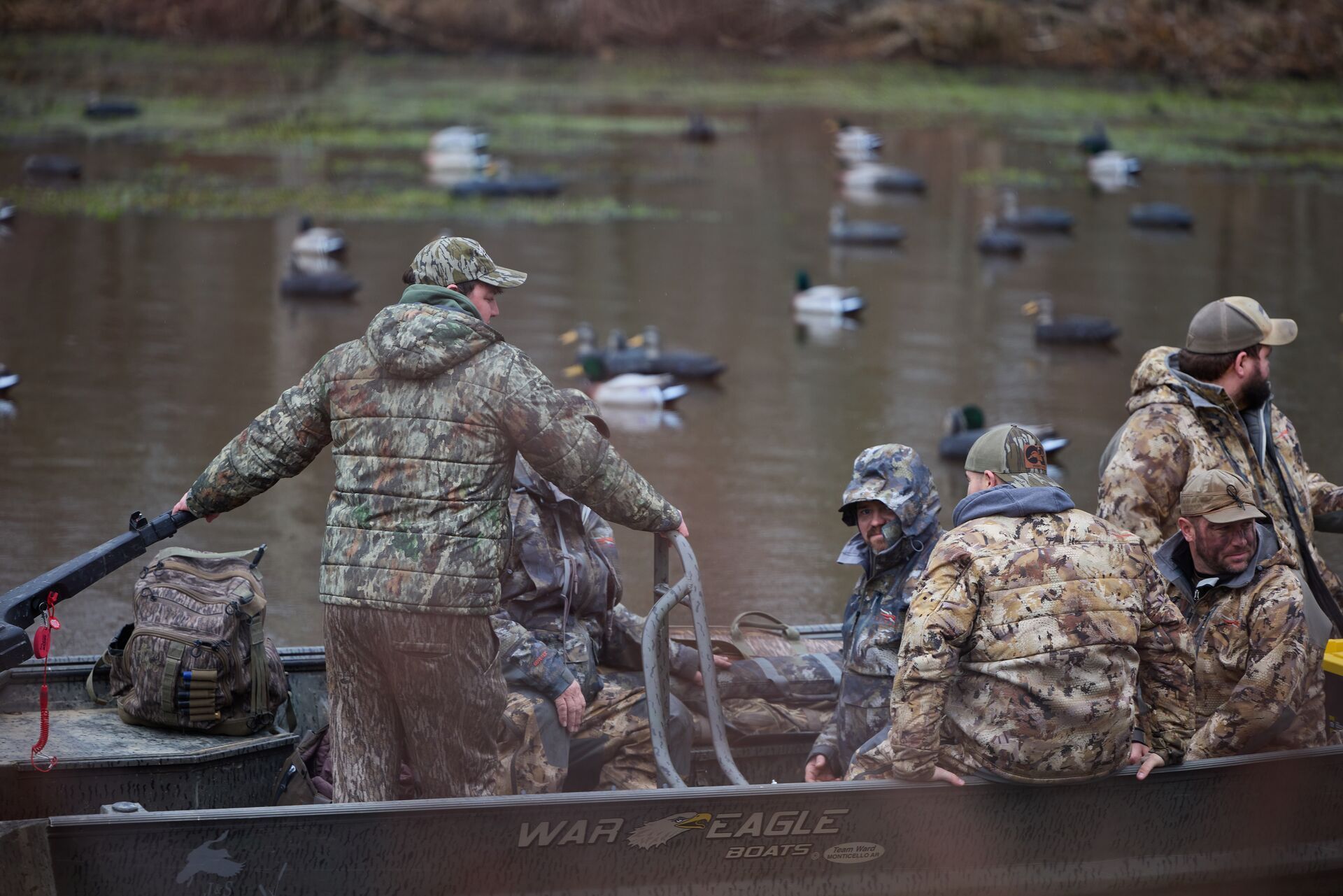 Boat full of waterfowl hunters surrounded by decoys, understanding flyways for waterfowl concept.