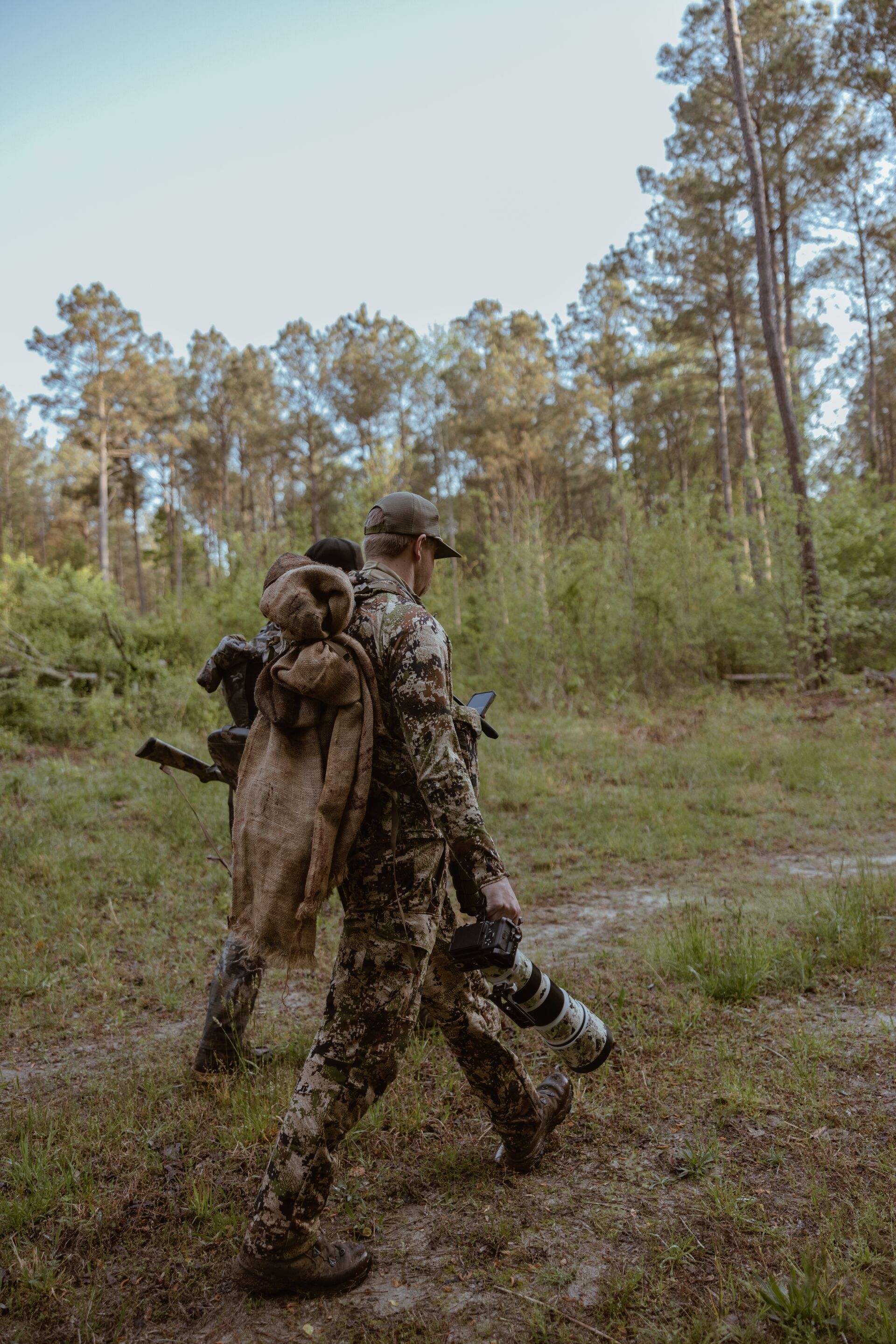 Two hunters with gear walk land, how to find public hunting land concept.