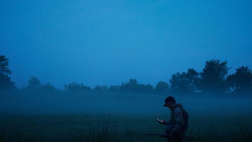 a-hunter-using-the-huntwise-app-at-dawn-using-deer-calls-concept. 