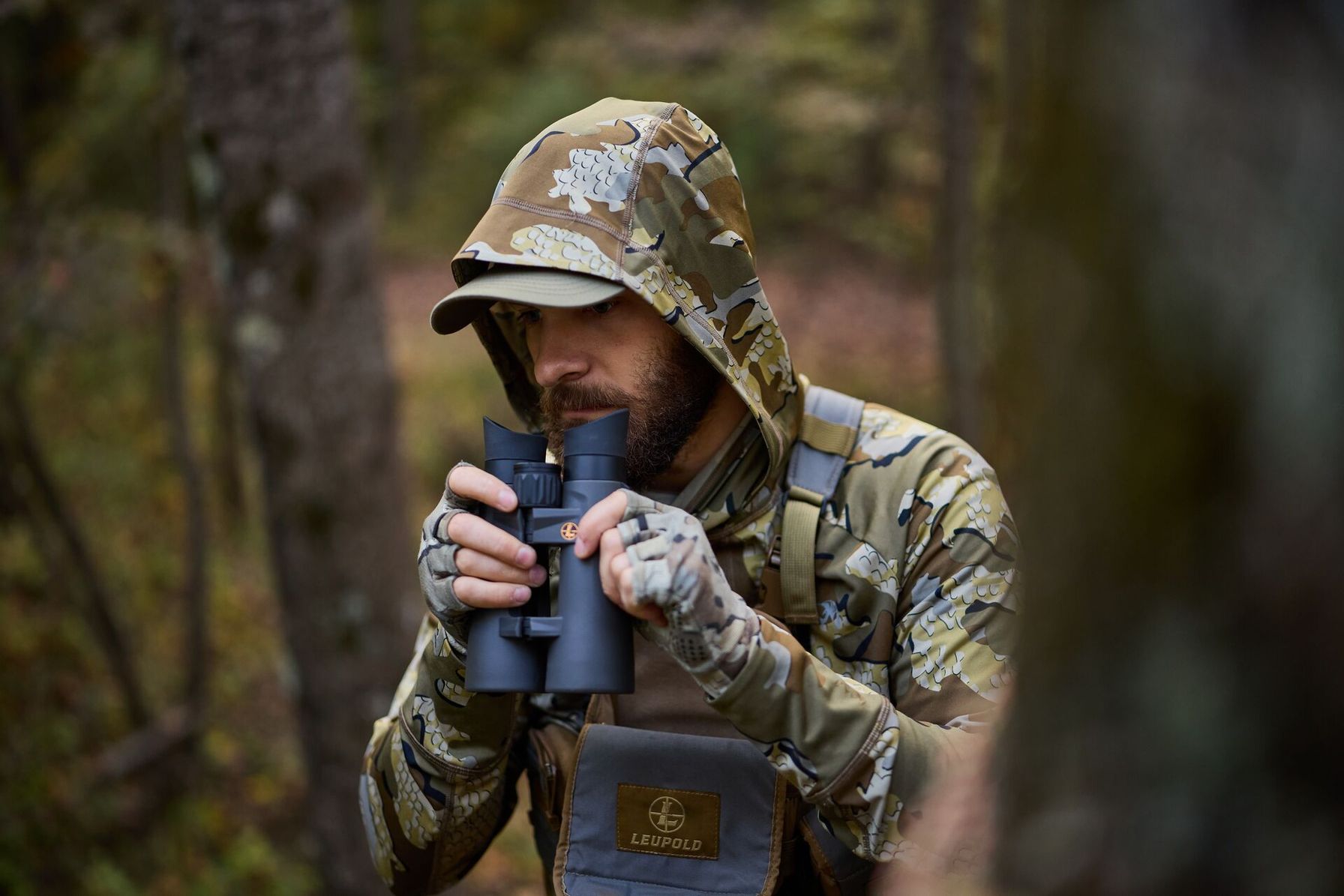 Hunter in camo using binoculars during hunt.