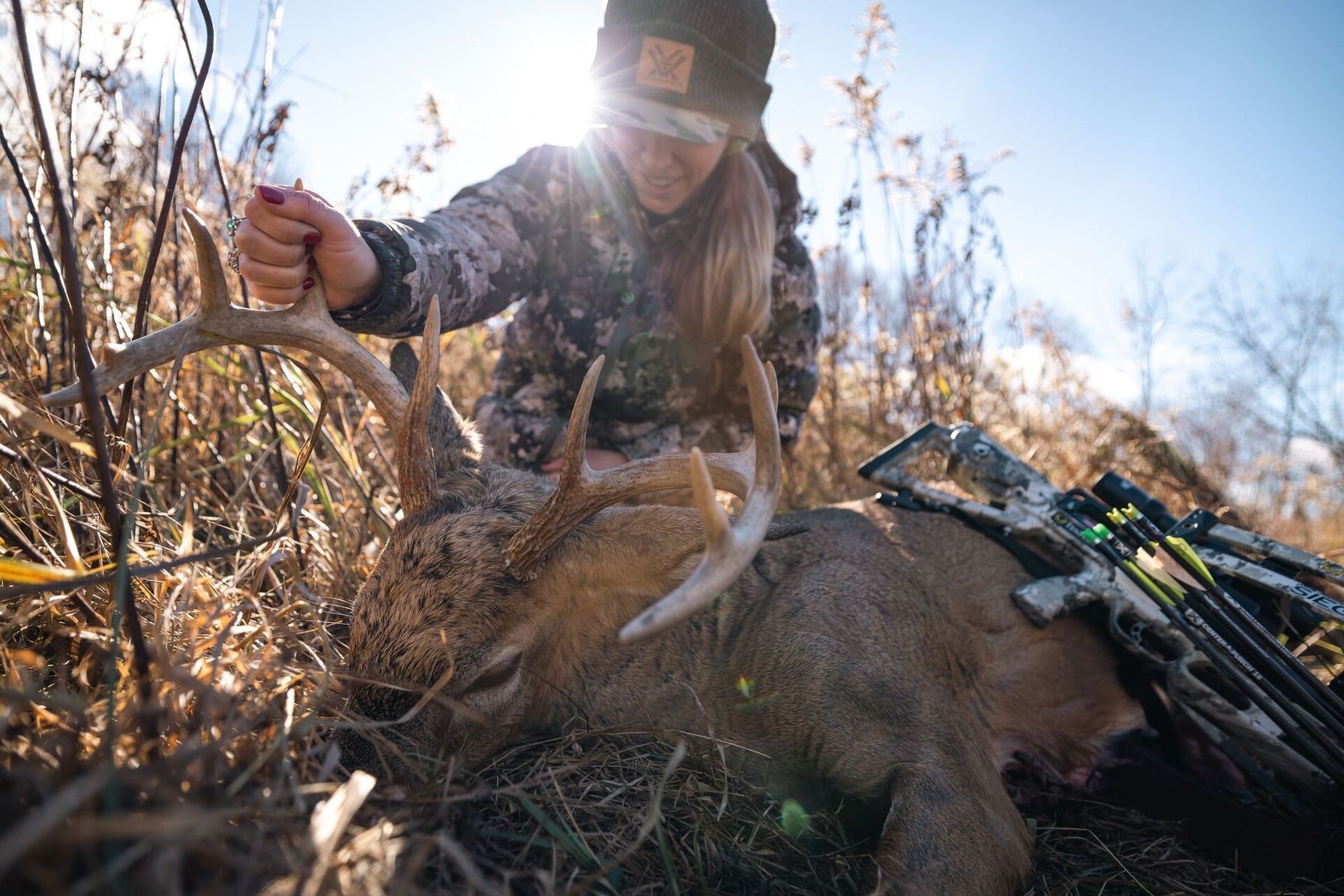 Female hunter shows off buck after hunt, deer hunting season in South Dakota concept.