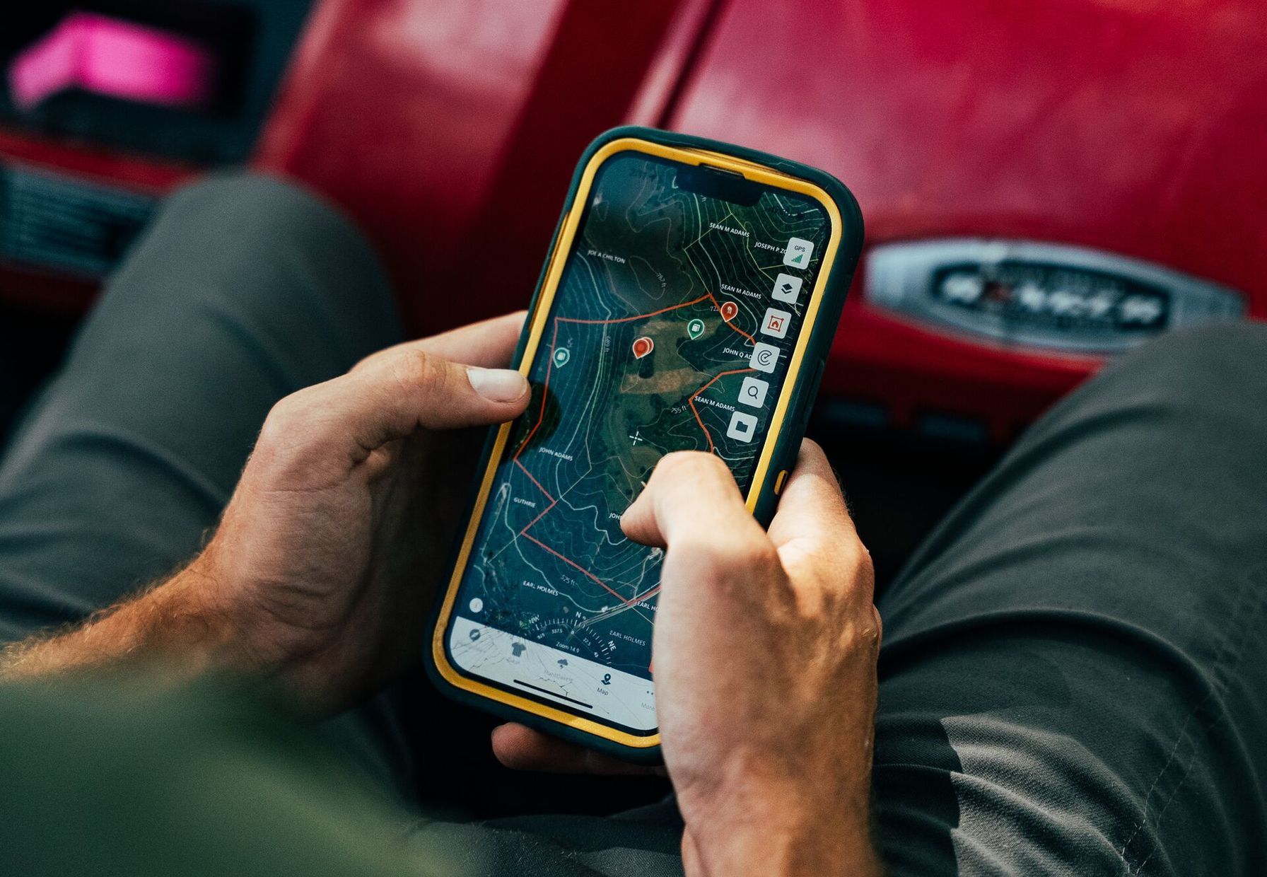 Close-up of hands using a phone showing HuntWise on screen, spring deer food plots concept.