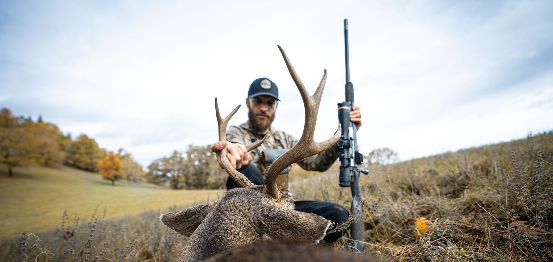 Hunter with rifle and buck deer after hunt, finding leftover hunting tags concept.