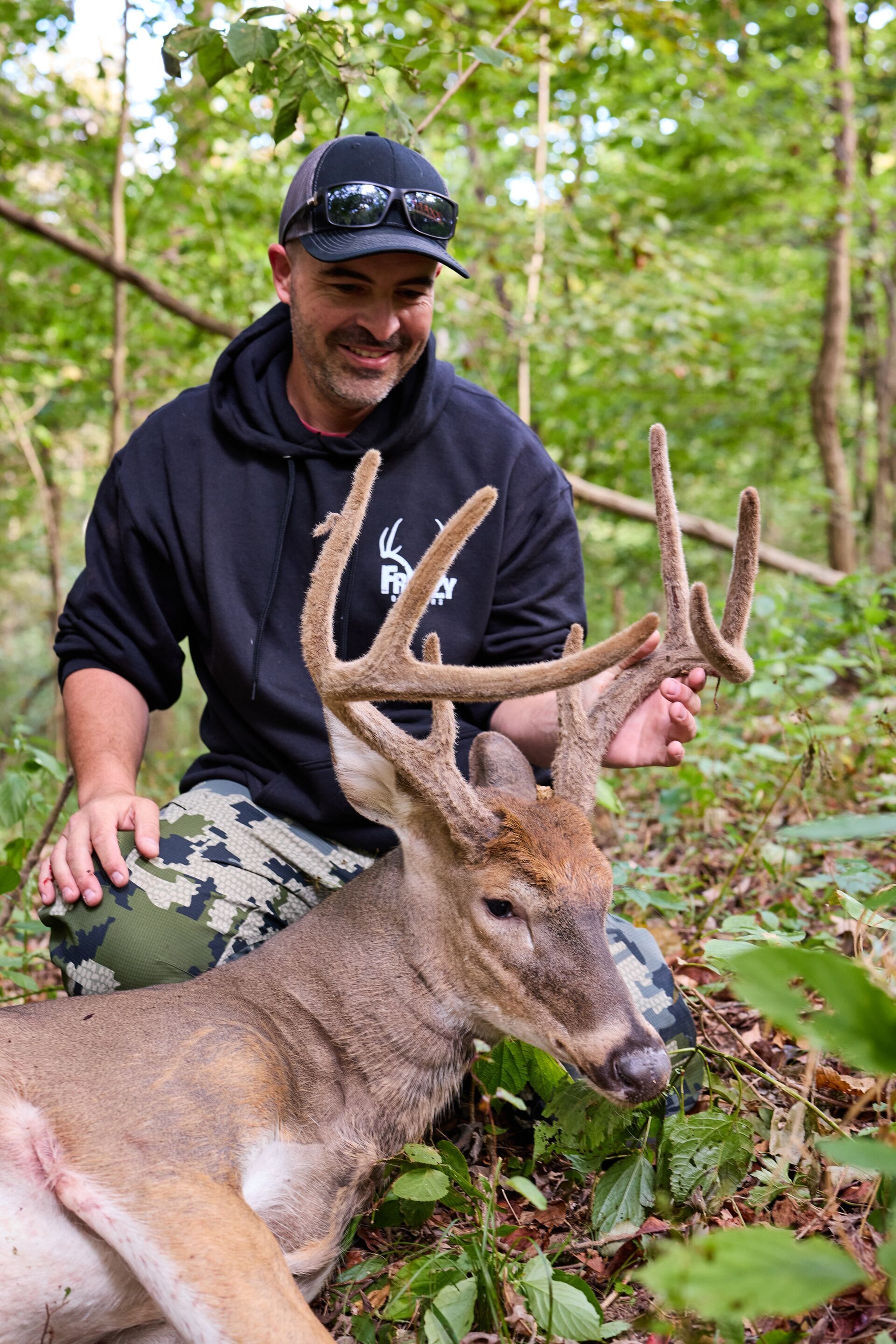 Hunter with buck deer showing velvet antlers, North Carolina deer season. 