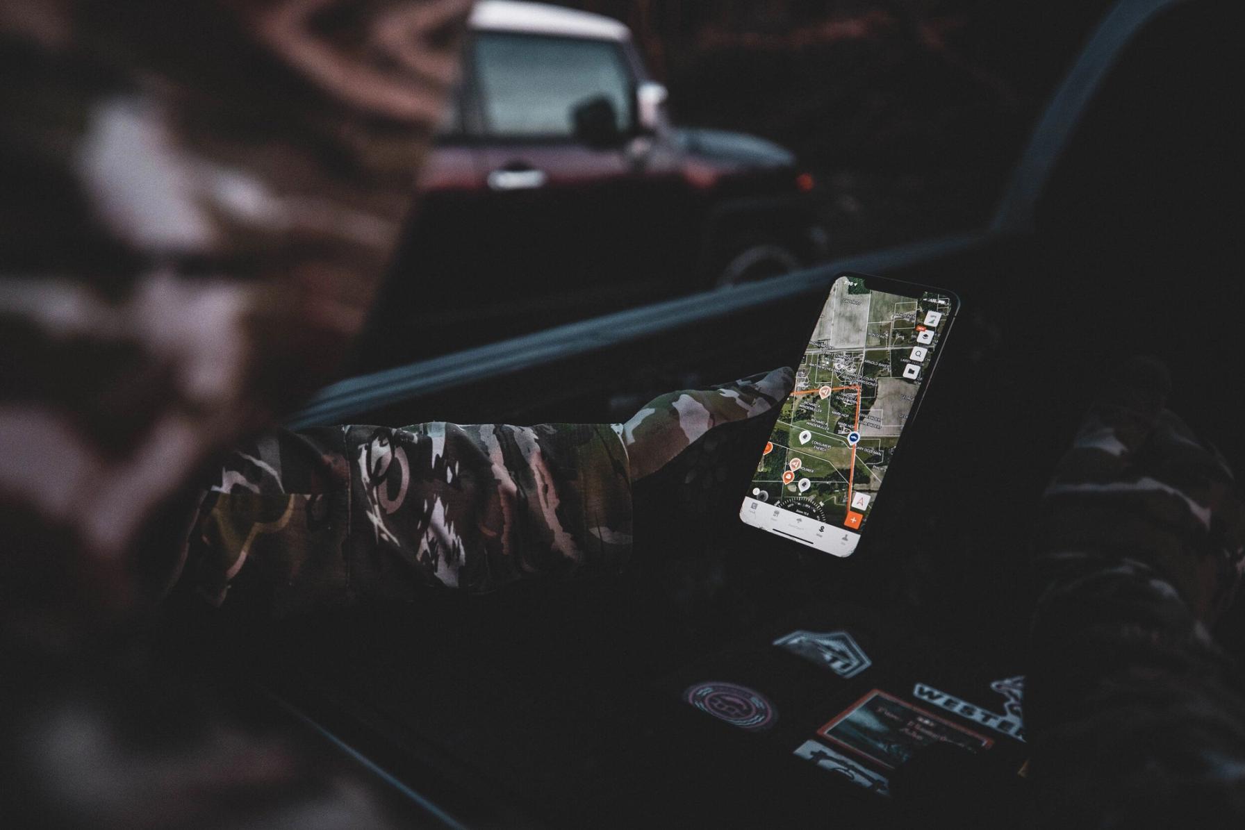 Hunter using the HuntWise app on a phone screen, how to find turkey hunting land concept.