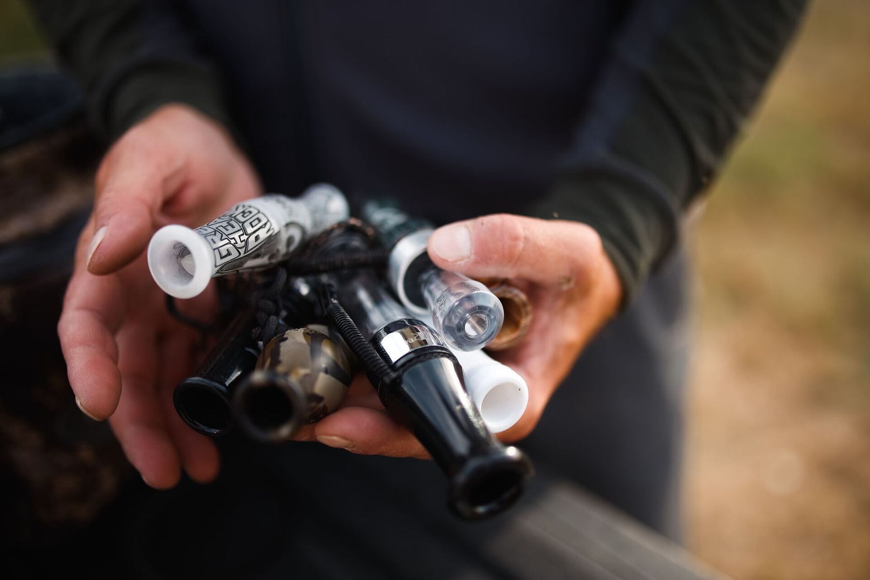 Hands holding various duck calls, best duck calls concept.