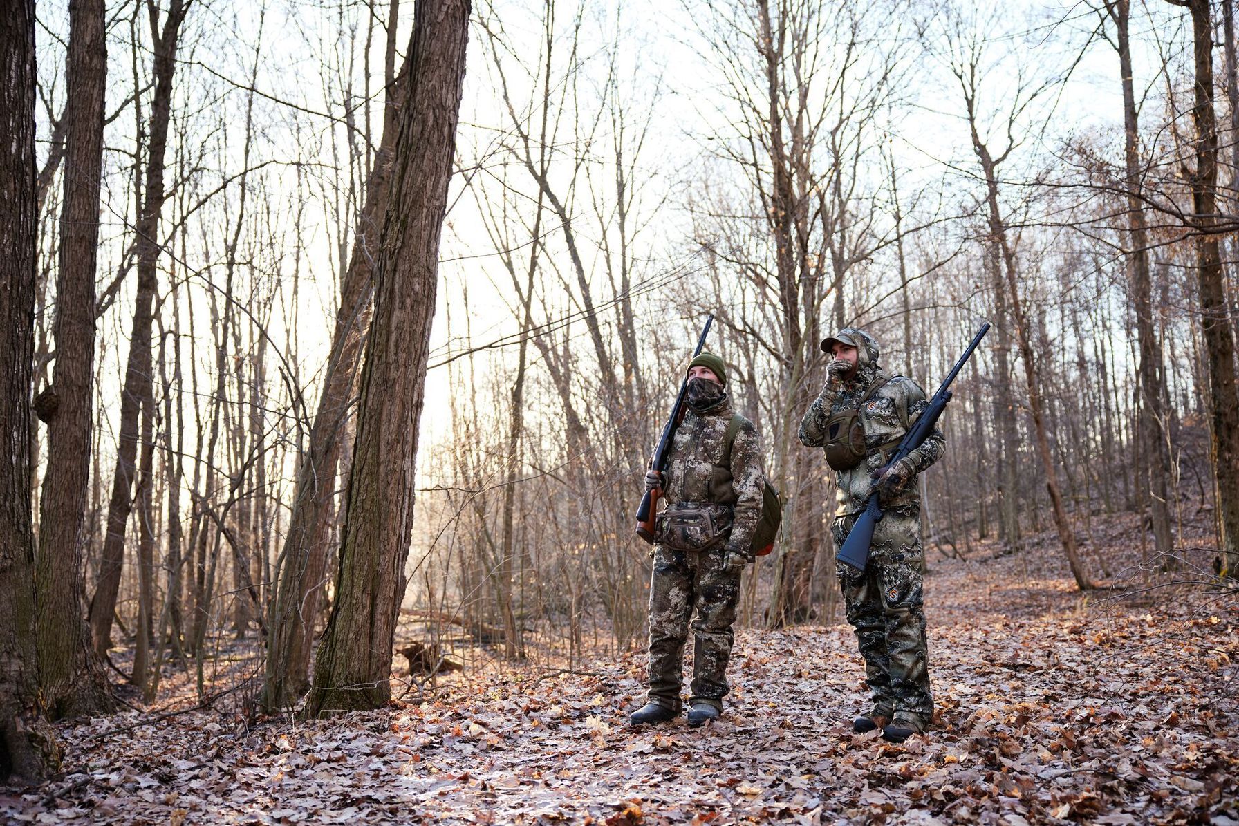Turkey hunters walk and call in the woods, how to hunt turkey in bad weather concept.