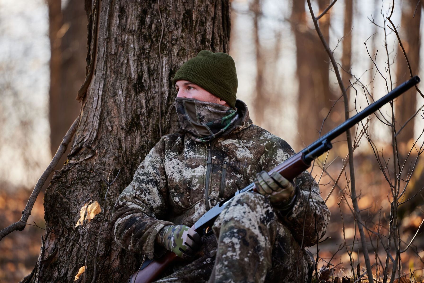 A hunter in camo sits in wait for a turkey, Alabama turkey season concept.