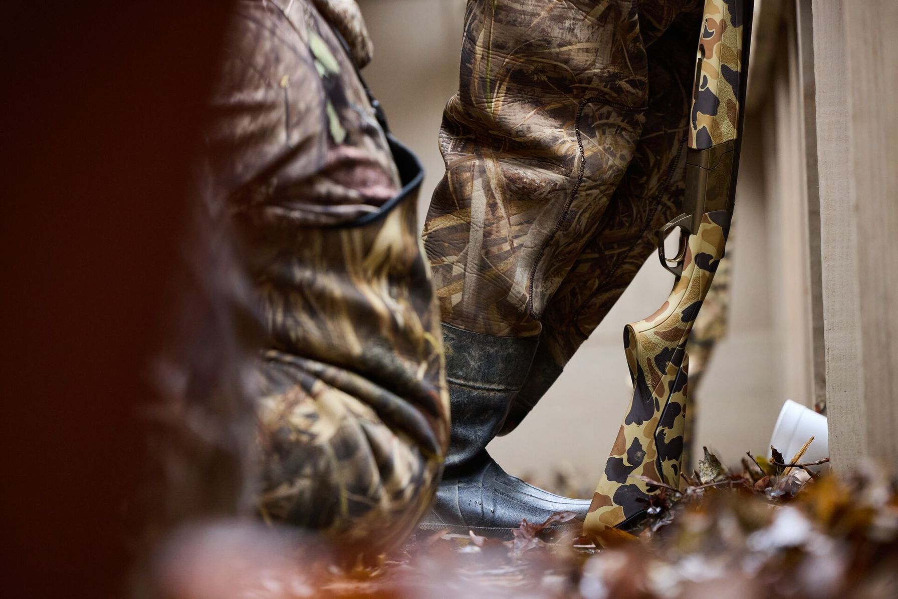Shotgun leans against wall for duck hunt.