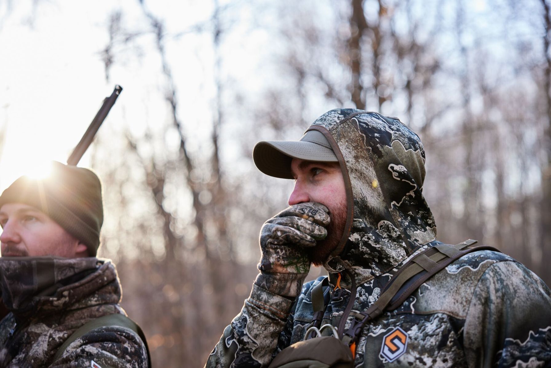 Two hunters in camo calling for turkeys, understanding wild vs heritage turkey concept.