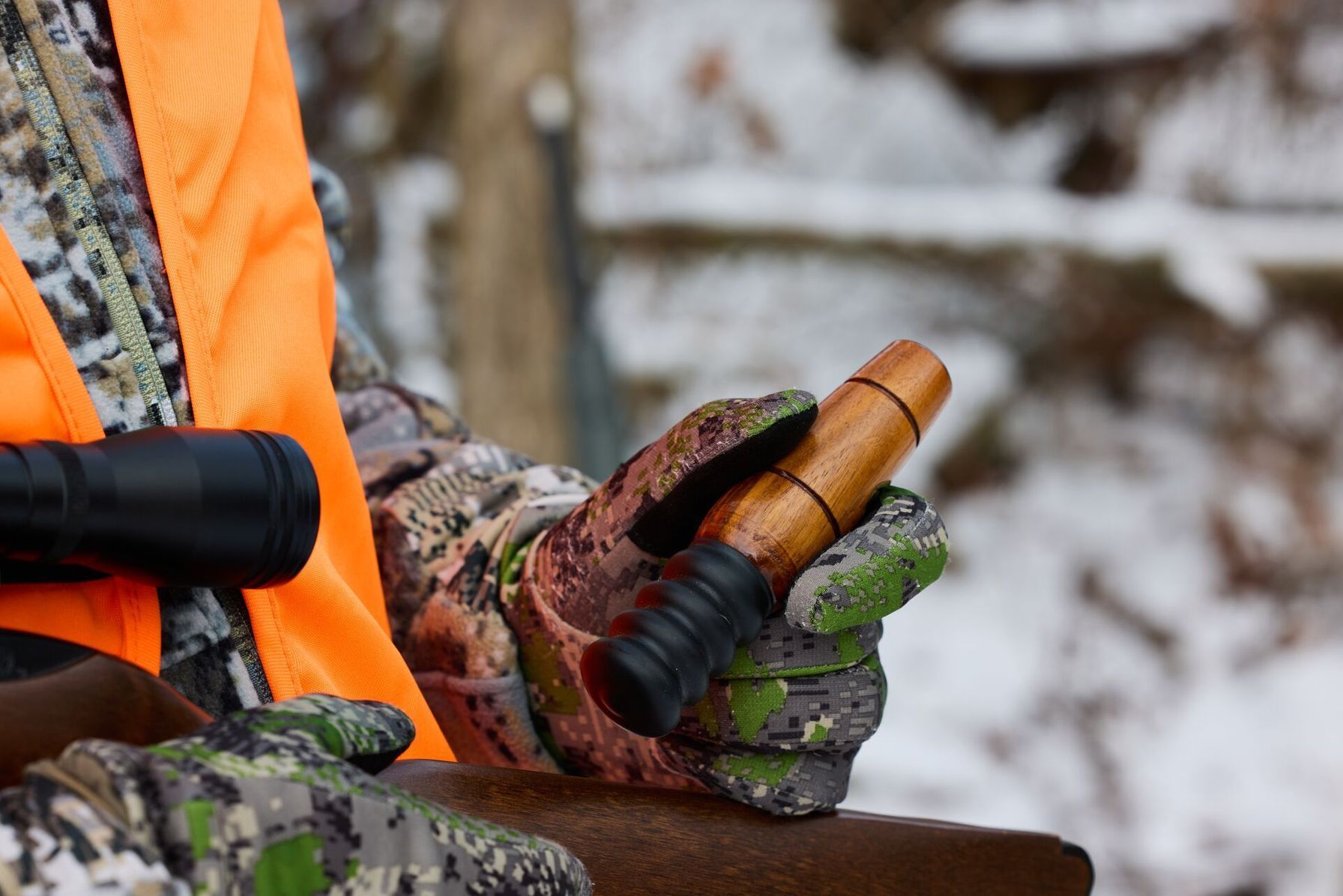 A hunter holds a game call used for hunting squirrels.