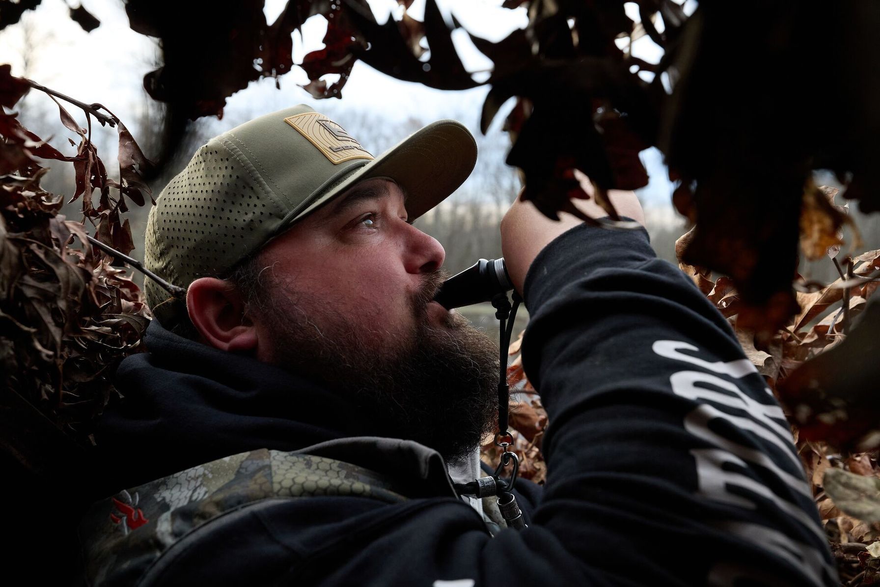 Hunter using duck call, best duck hunting equipment concept.