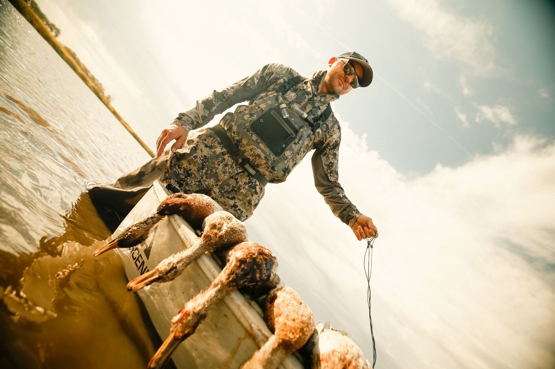 Hunter with geese in canoe after hunt, goose hunting season concept.