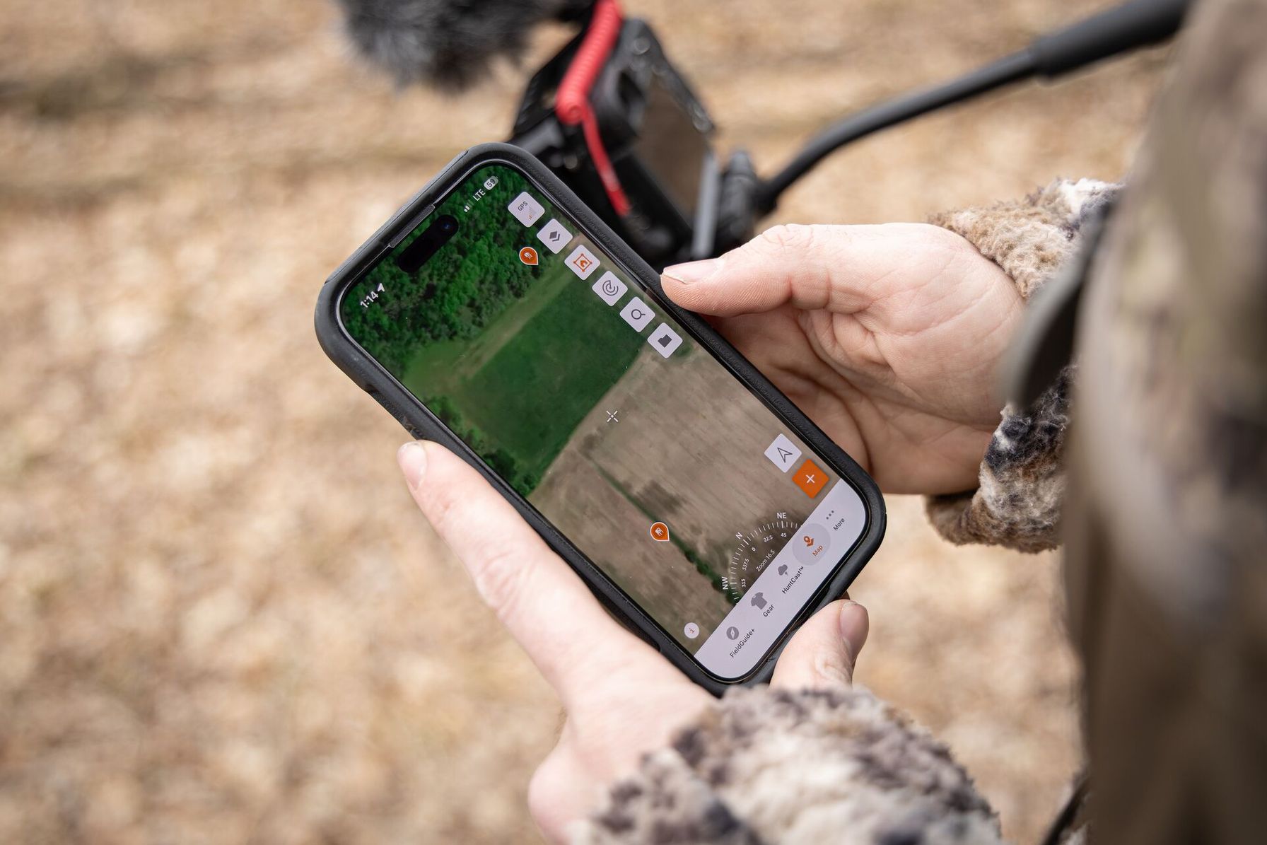 Close-up of HuntWise map on phone screen, hunting permission private land concept.