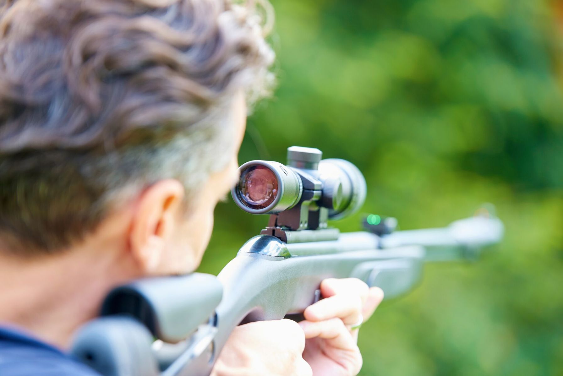 A man aims an air rifle, learning about gun types concept.