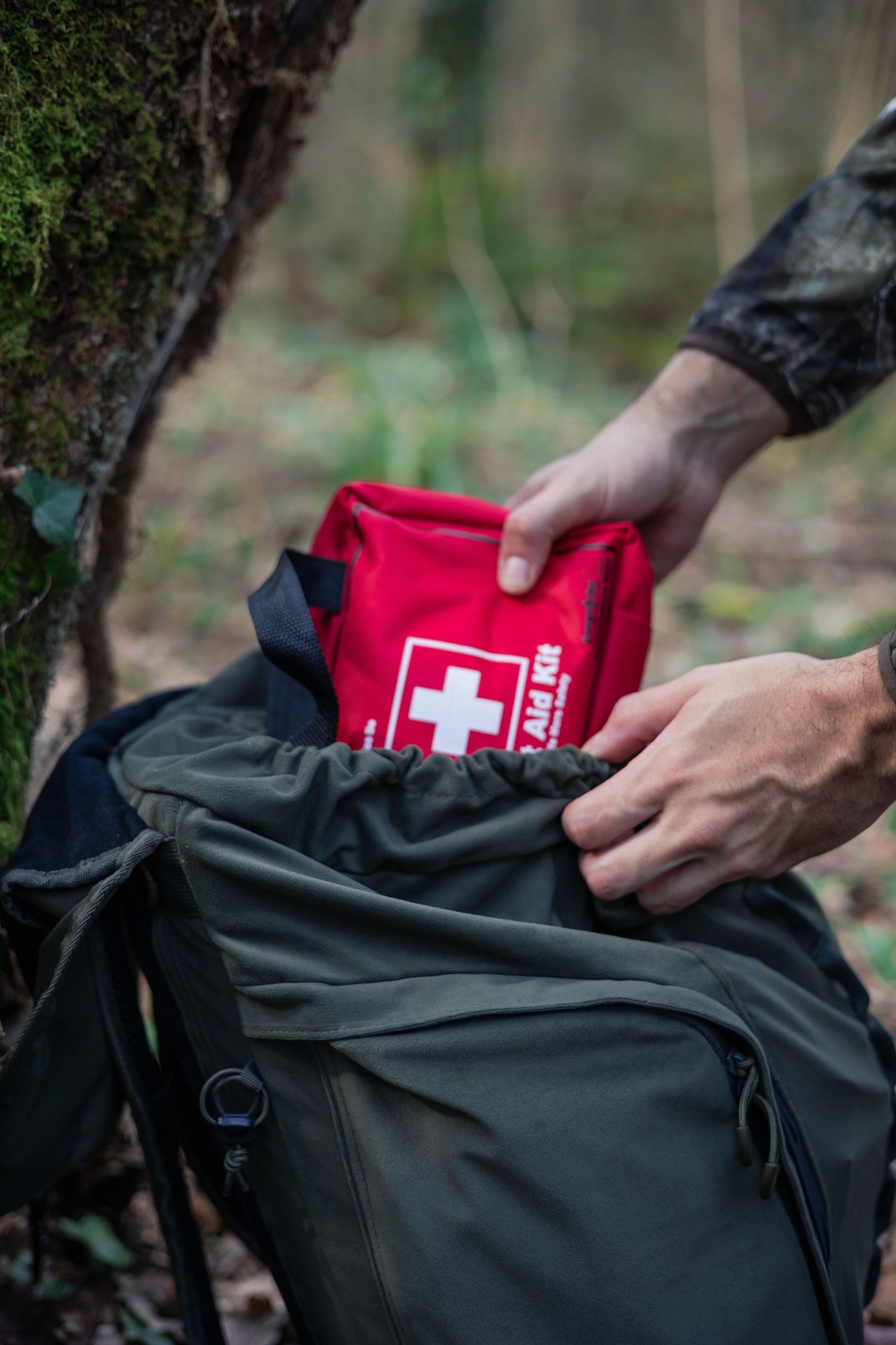 Packing a first aid kit into a hunting pack, hydration safety tips concept.