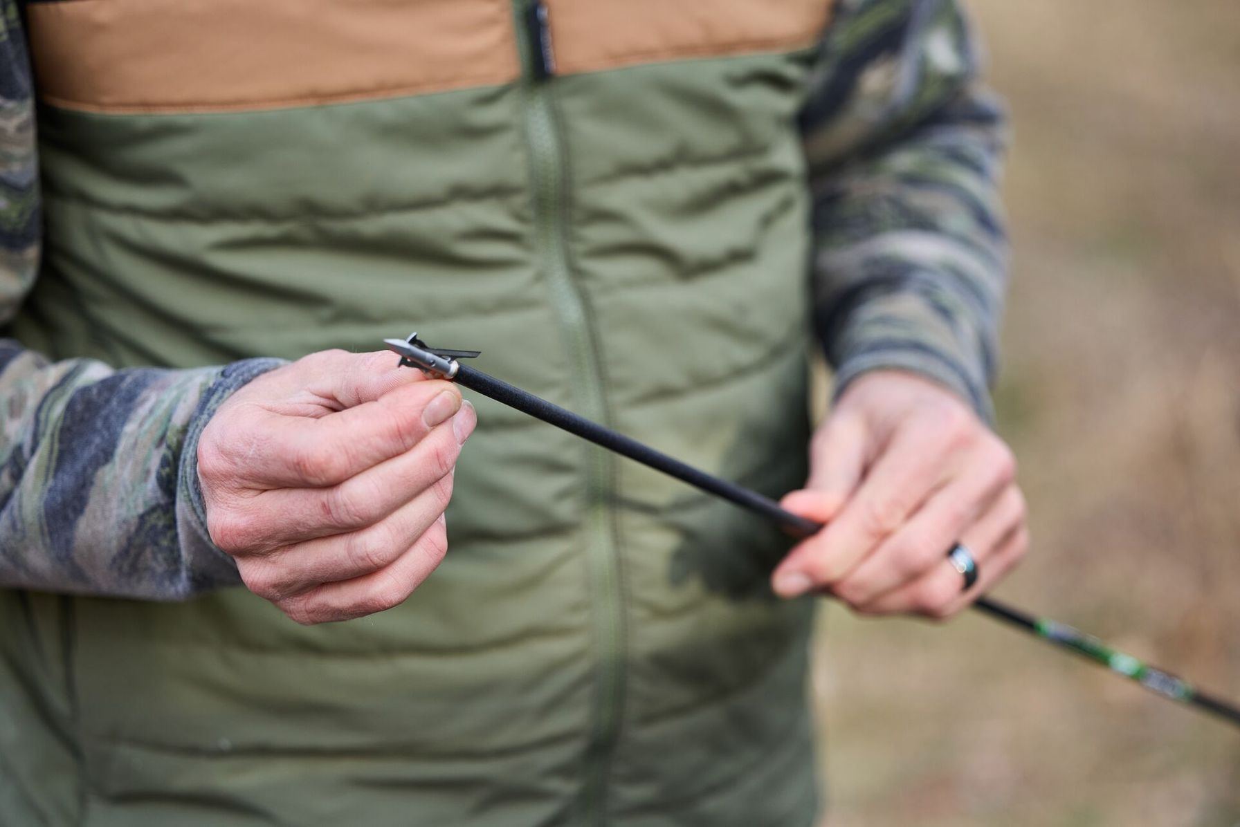 Close-up of hunter holding the tips of an arrow attached to the shaft.