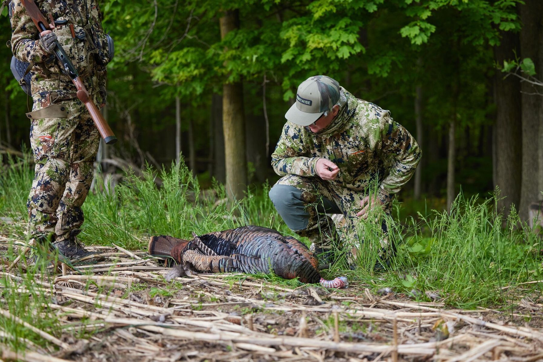 Hunters with a turkey on the ground after a hunt.