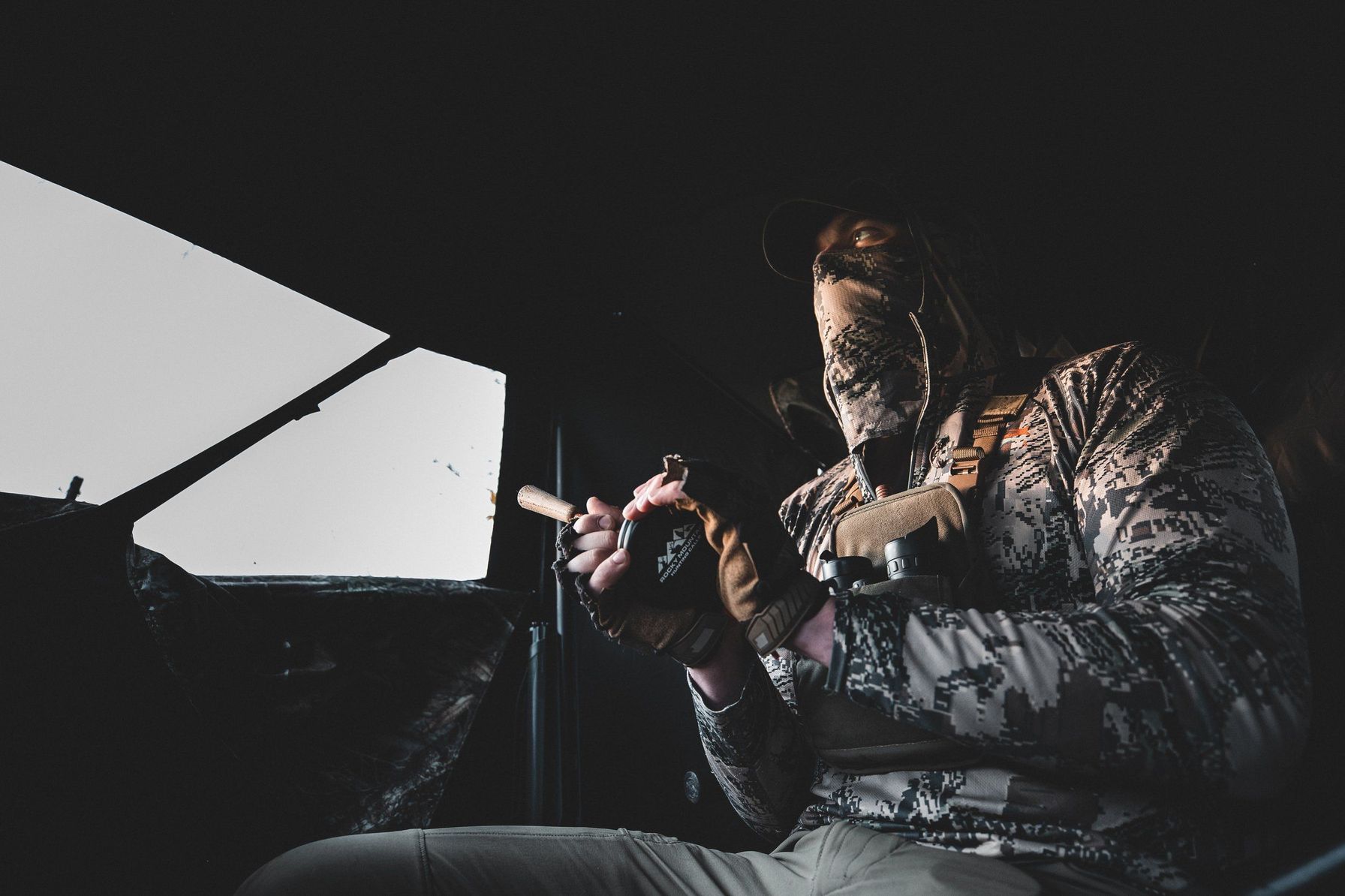 Hunter in a turkey blind uses a slate call.