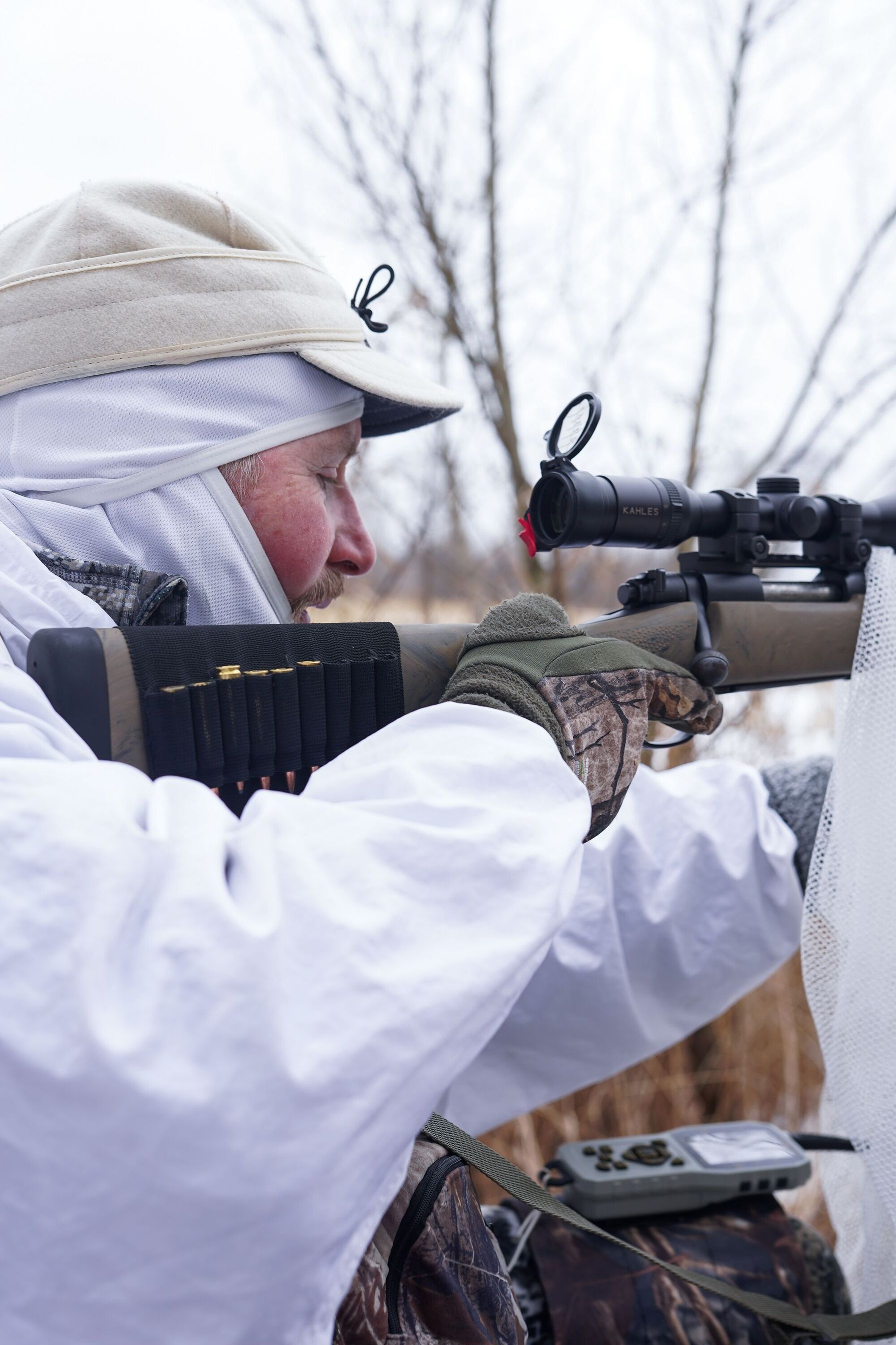 Hunter in white gear for snowy hunt.