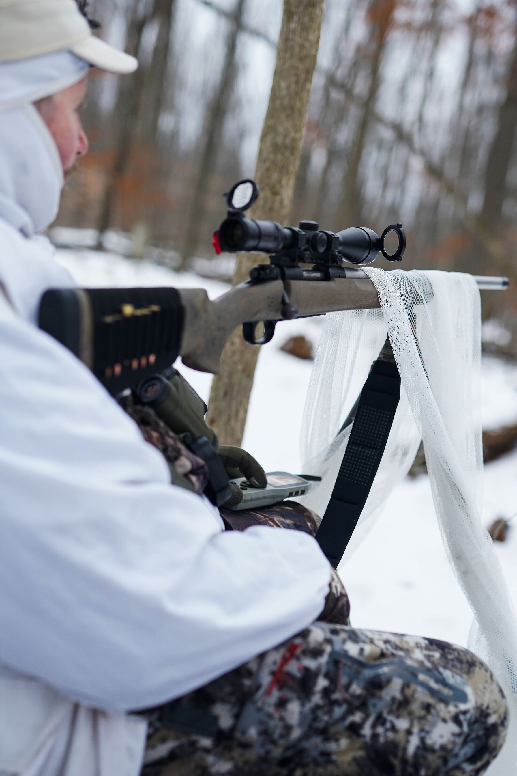 Hunter set up in woods for coyote hunt, hunting invasive species concept.