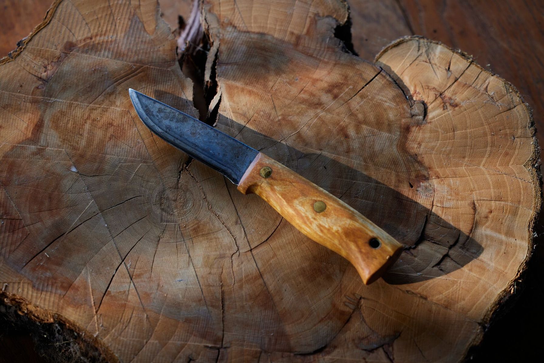 A fixed-blade knife with a wooden handle, consider the handle when choosing hunting knives concept.