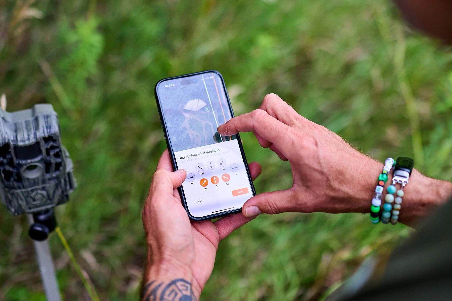 Hunter using HuntWise to set up trail cameras, where can I go hunting near me concept.