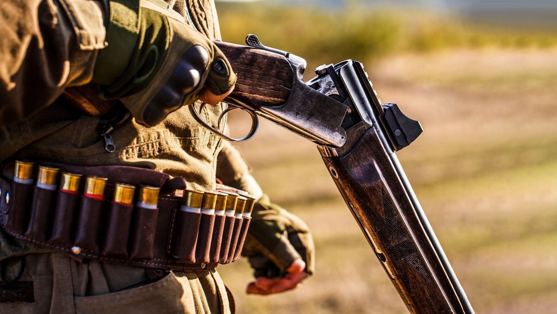Close-up of hunter with break-action shotgun.