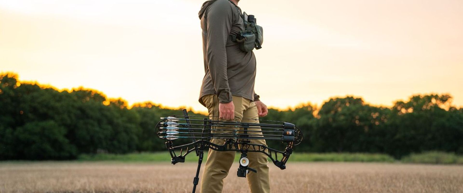 Hunter in field with bow ready for hunt, how to find walk-in hunting in Ohio concept. 