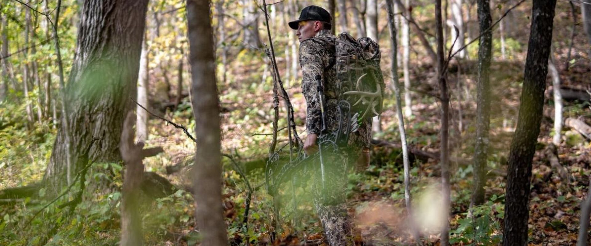 A hunter in camo with gear in the woods, do scent blockers work concept.