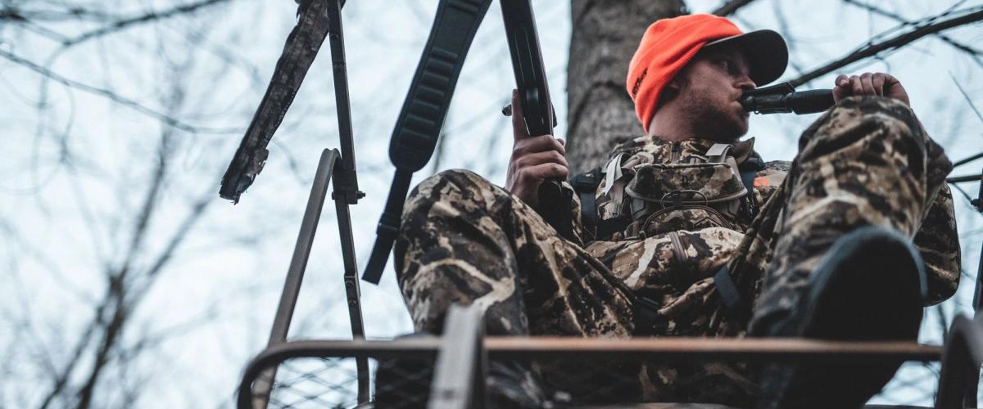 A hunter uses a deer call, calling bucks concept.