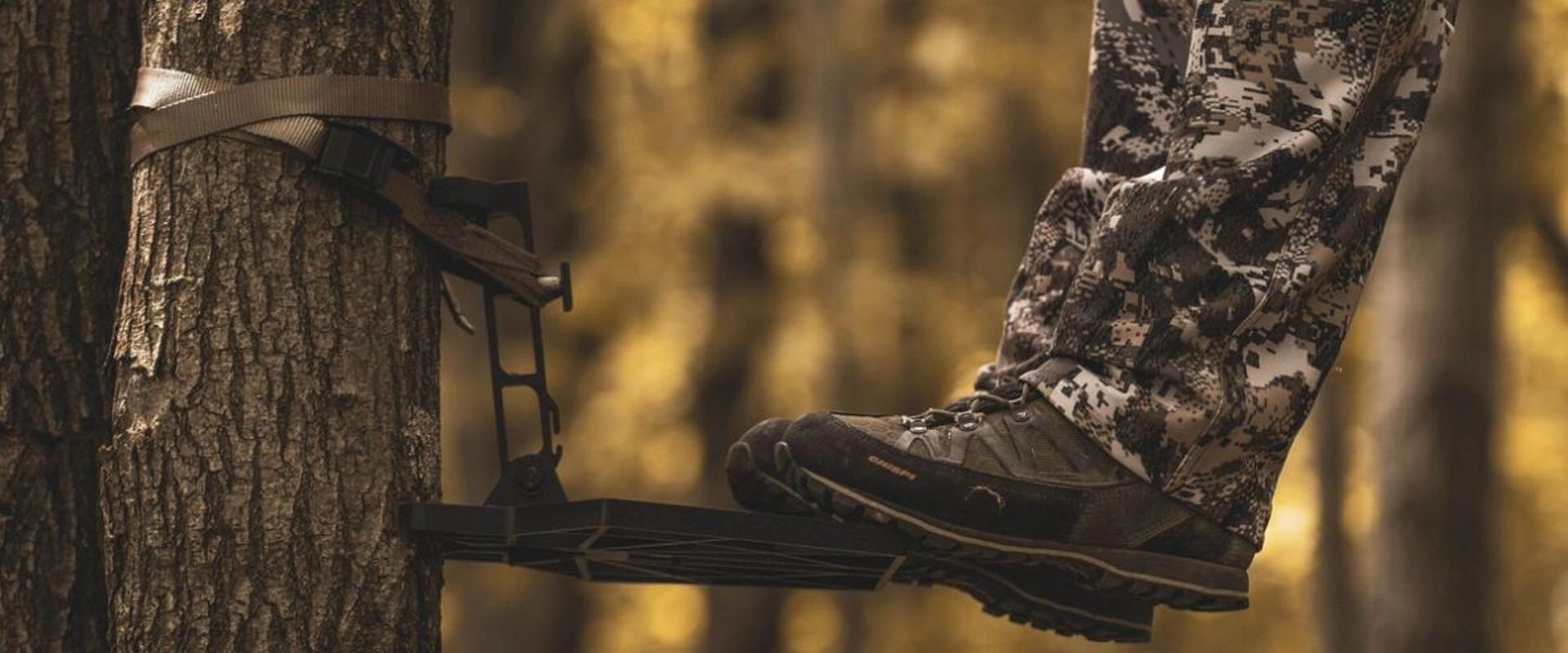 Close-up of a hunter's feet on a saddle hunting platform in a tree.