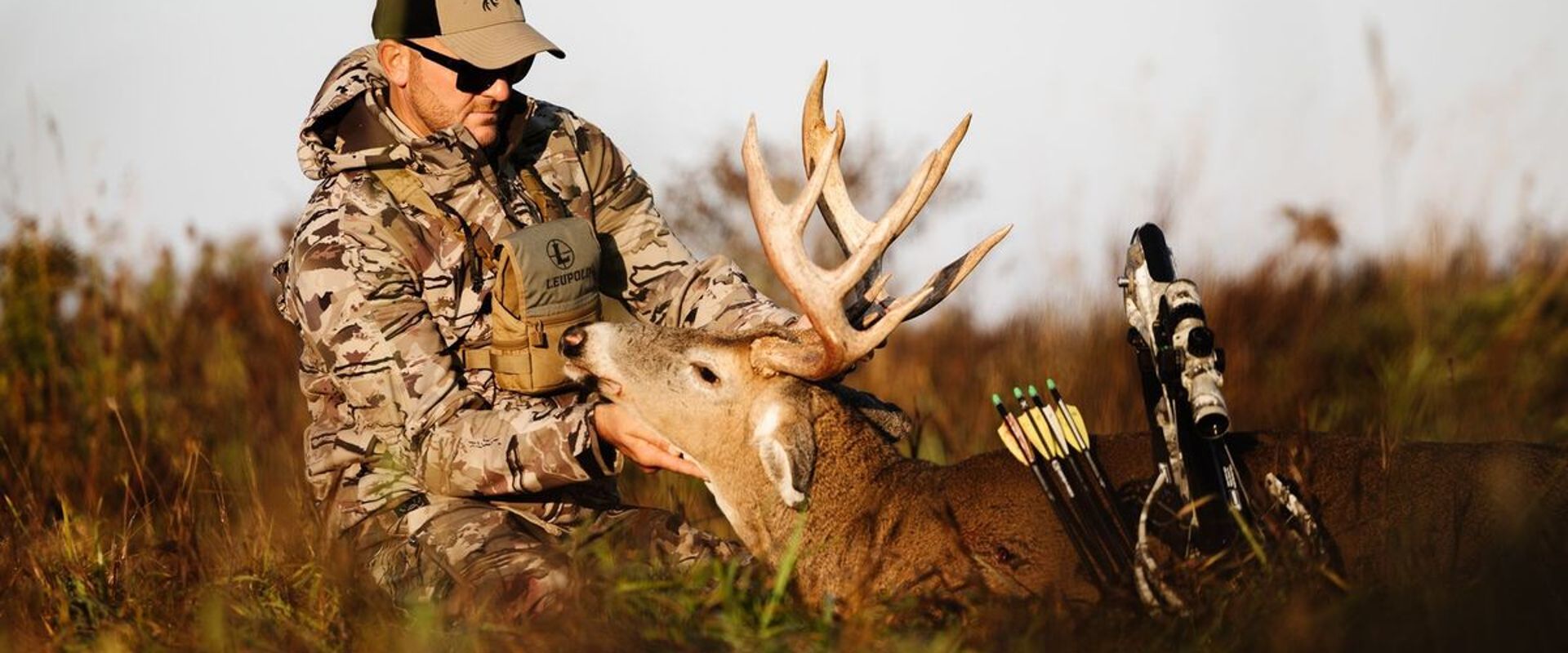 A hunter holds a deer's head and antlers after hunt, what diseases do deer carry concept.
