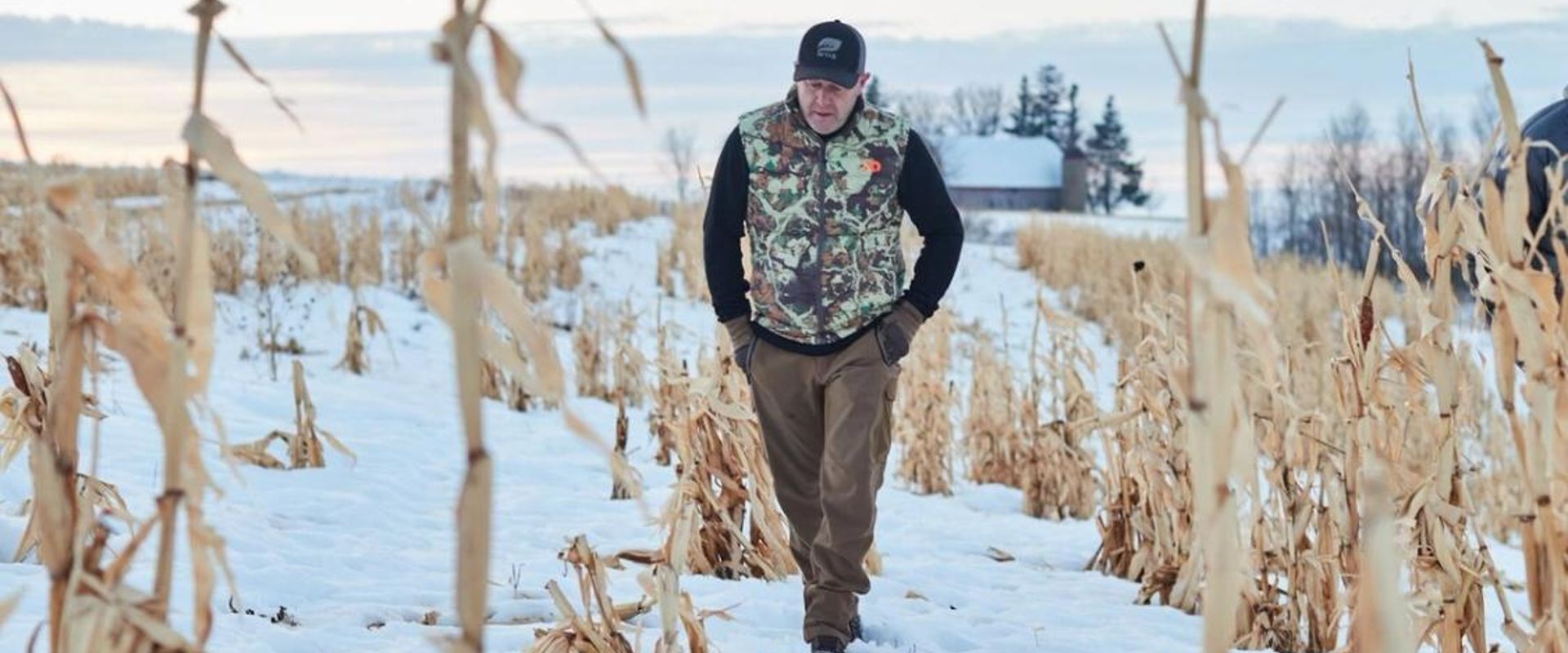 Jeff Sturgis walks through a snowy field, understand weather and deer movement concept.