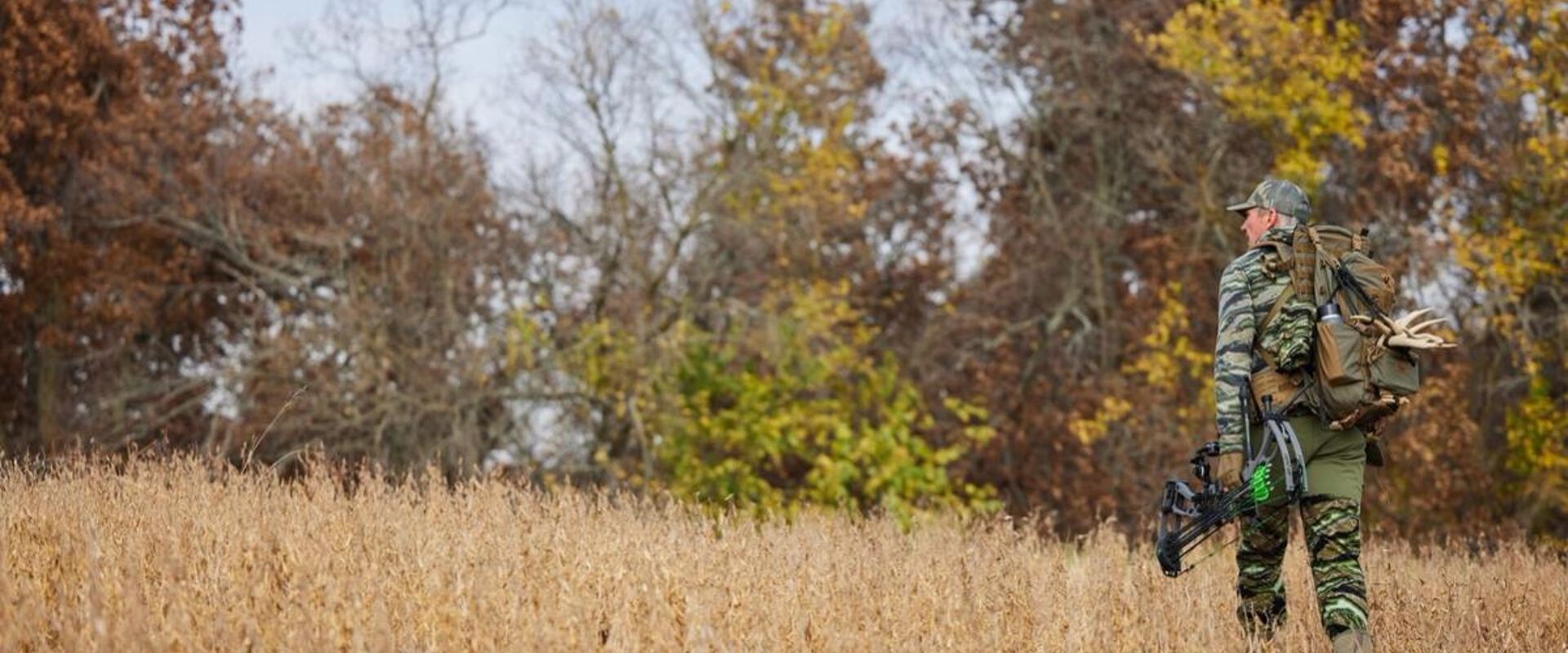 Hunter John Dudley walks a field with hunting gear, how to get permission to hunt private land concept.