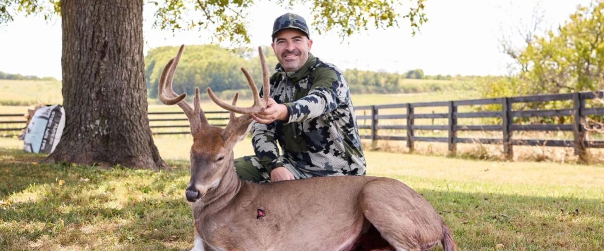 Hunter with buck deer after hunt showing clean shot, where to shoot a deer concept.