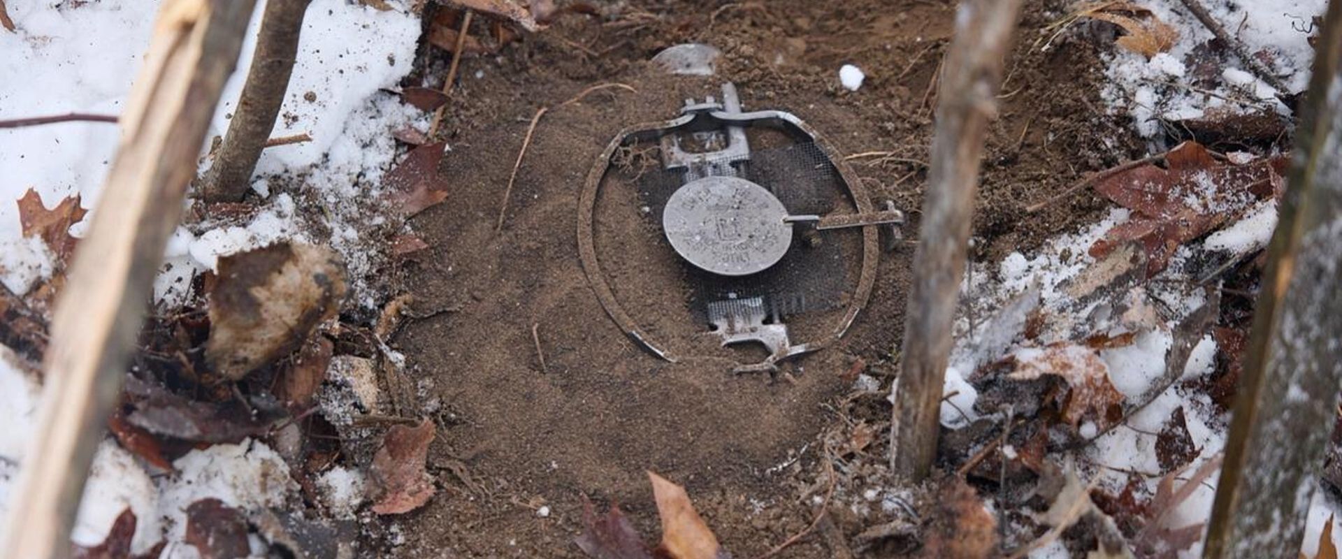 Live animal trap set in the dirt, how to start trapping concept.