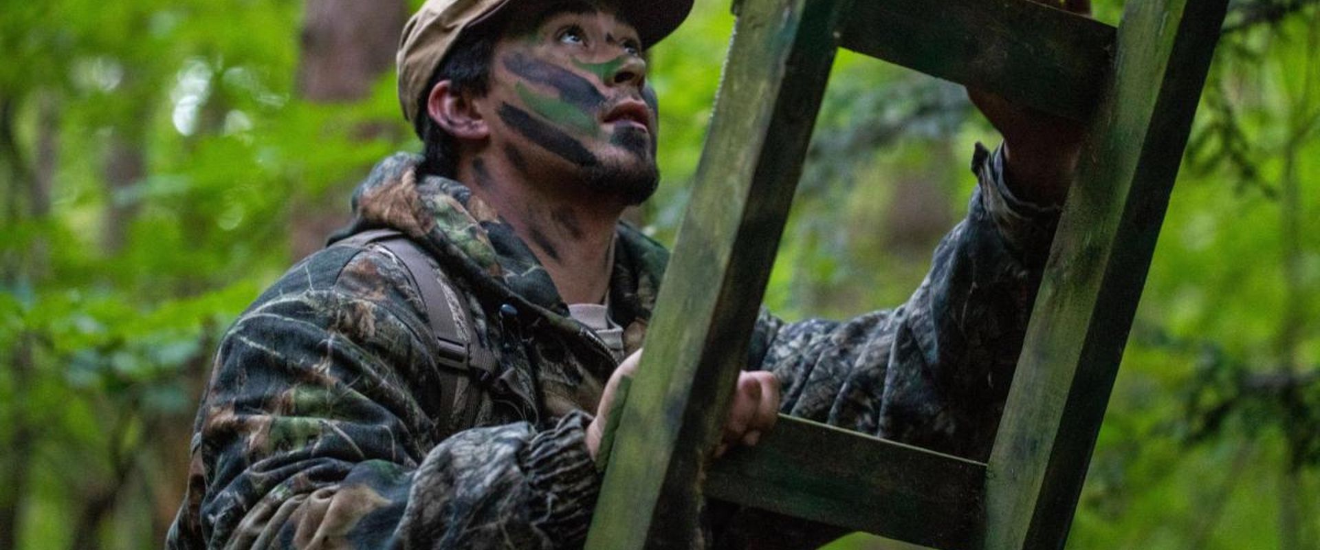 A hunter climbs a ladder to a treestand.
