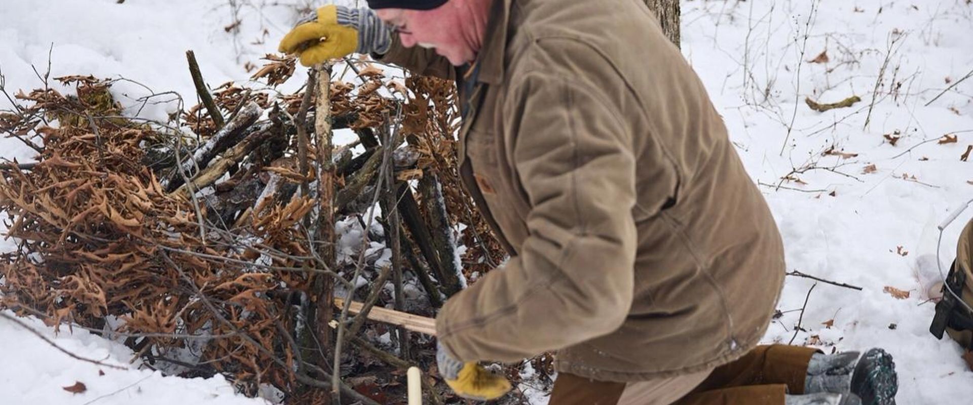 Man sets trap in the snow, PA trapping season concept.