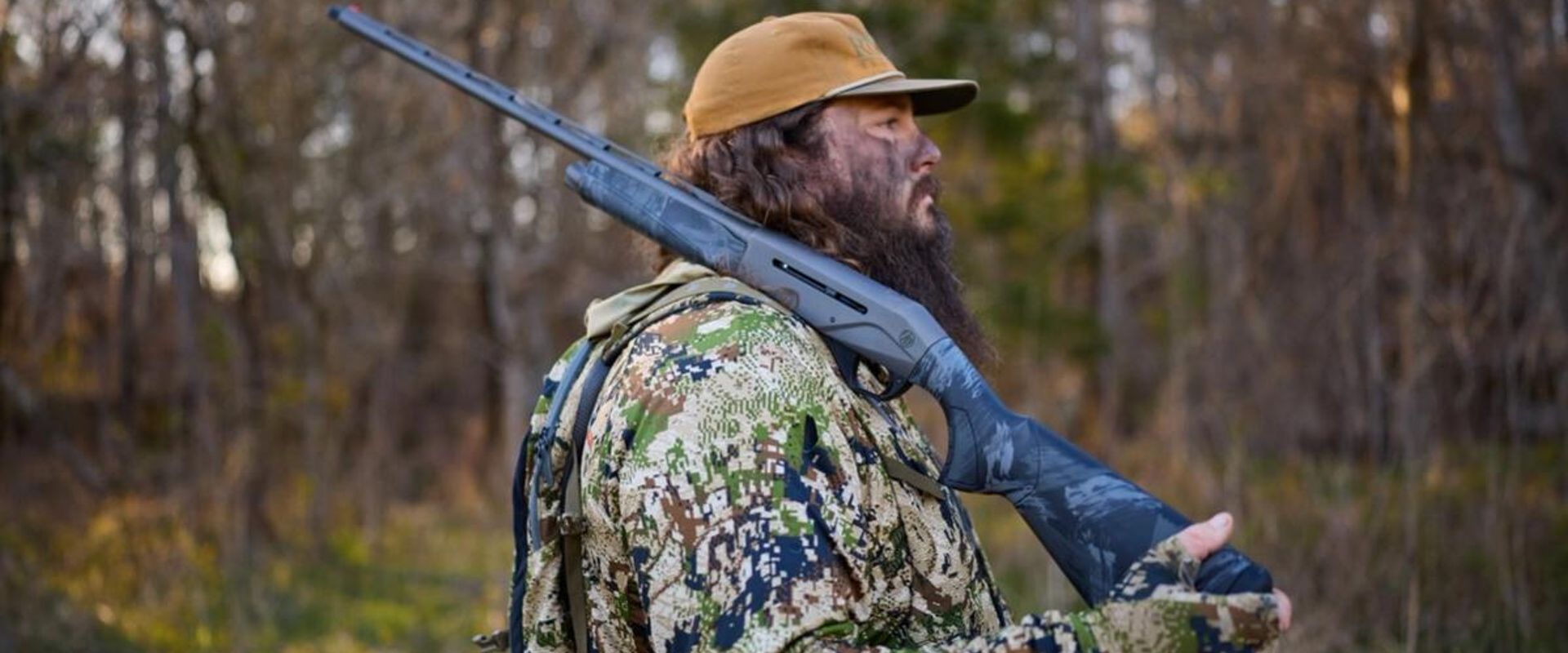 Side view of hunter with shotgun on shoulder, shotgun for hunting concept.