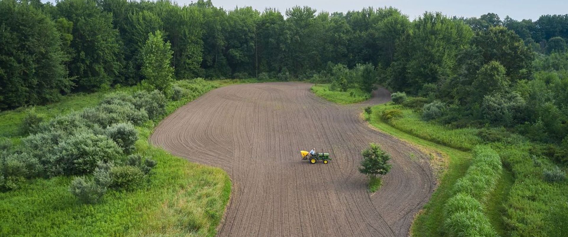 Overhead view of a tractor on farm land, how to find property lines in Idaho concept. 