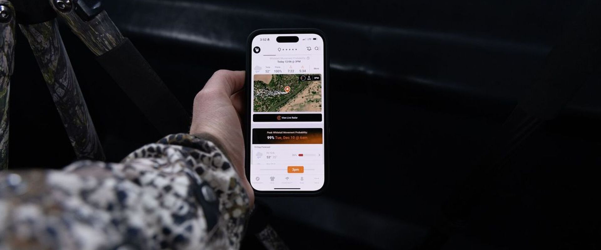 Hunter's hand holding a phone showing HuntCast in the HuntWise app.
