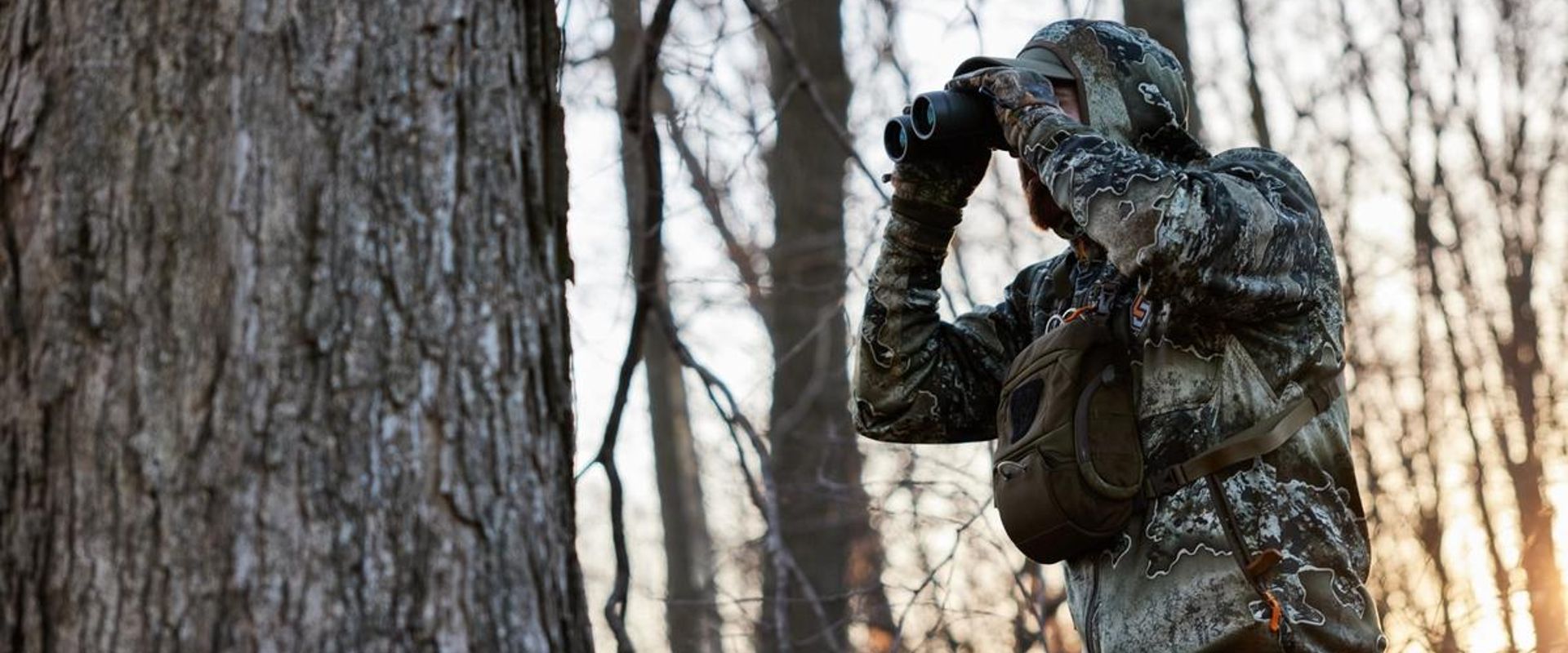 A hunter uses binoculars, best hunting binoculars concept.