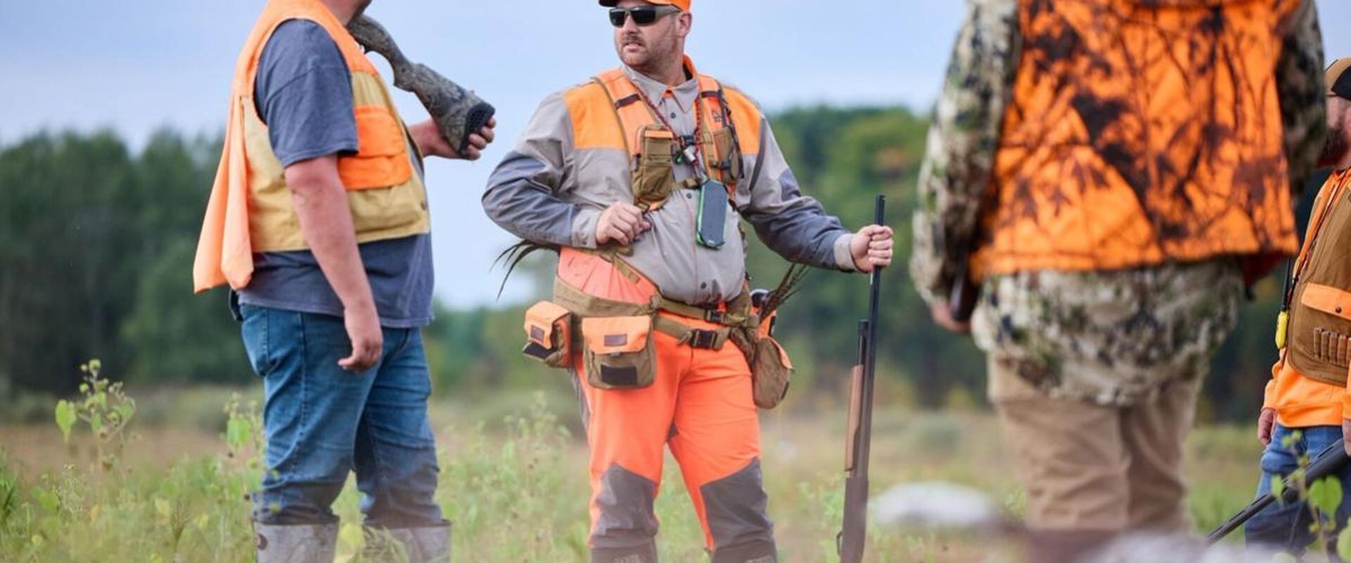 Three hunters in blaze orange ready for hunt, pheasant hunting Wisconsin concept.