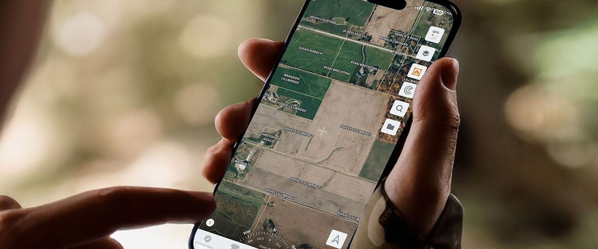 Hand holding phone showing land lines in HuntWise app, hunting maps with property lines concept.