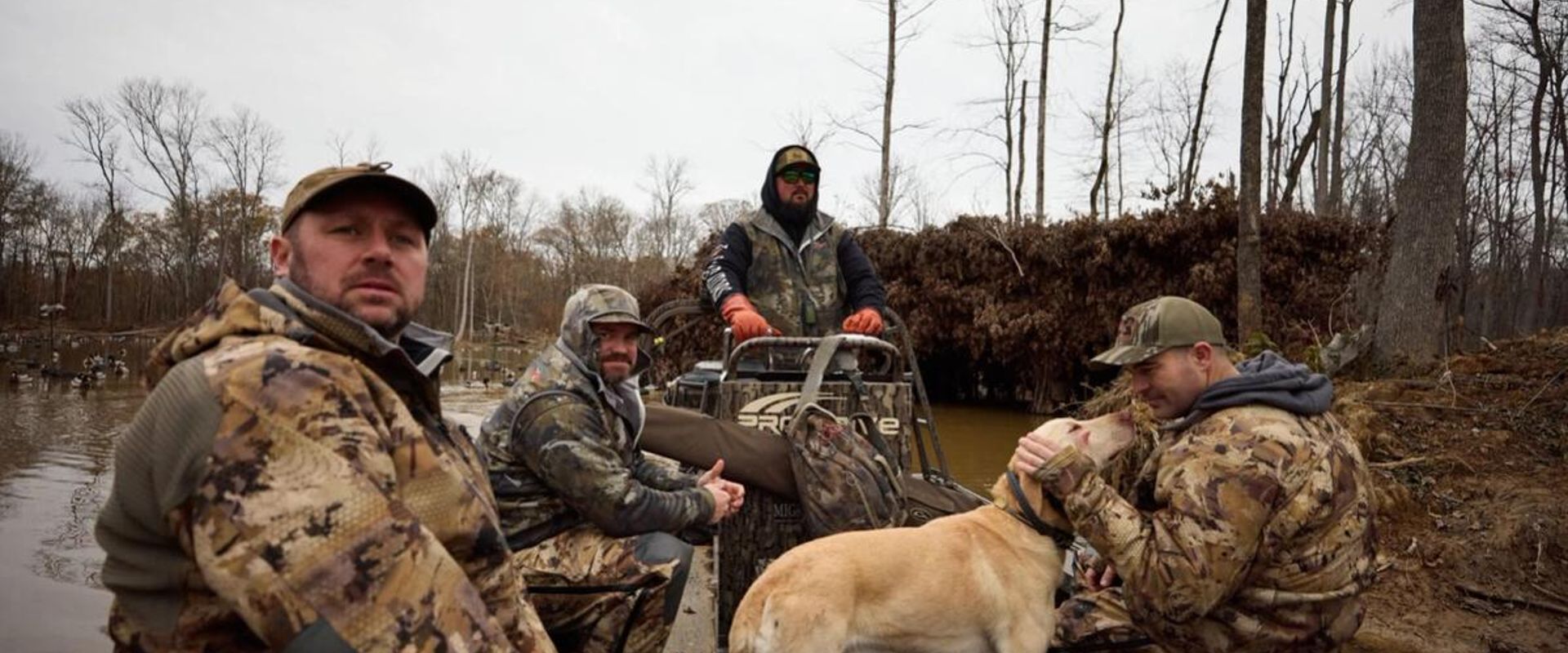 Hunters in boat with dog for waterfowl hunt, public waterfowl hunting land in Kansas concept.