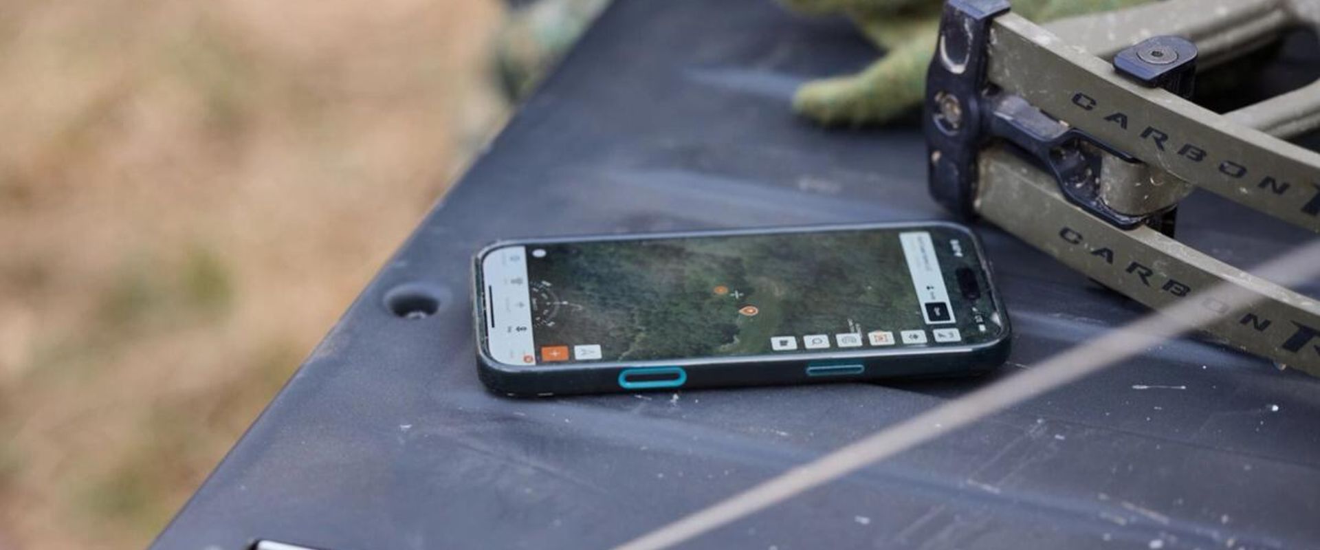 Phone on truck tailgate showing hunting app, HuntWise vs GoHunt concept. 