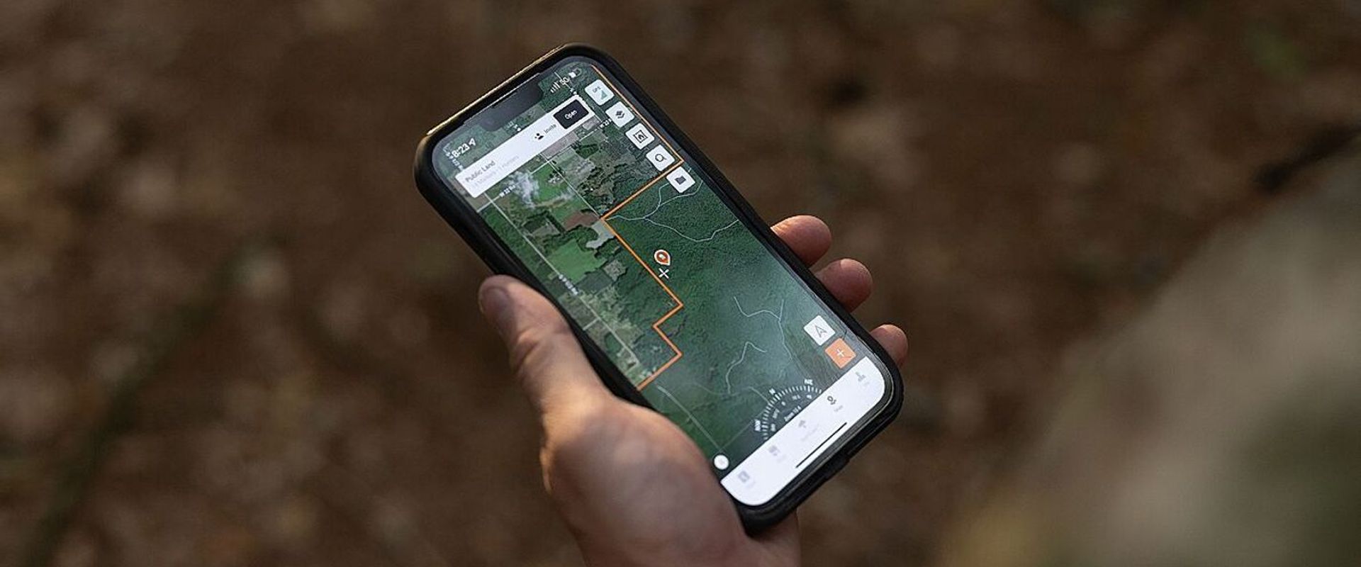 Hand holds a phone showing HuntWise property lines, 